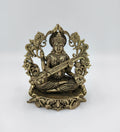 Small brass Saraswathi idol seated with veena and decorative floral backdrop