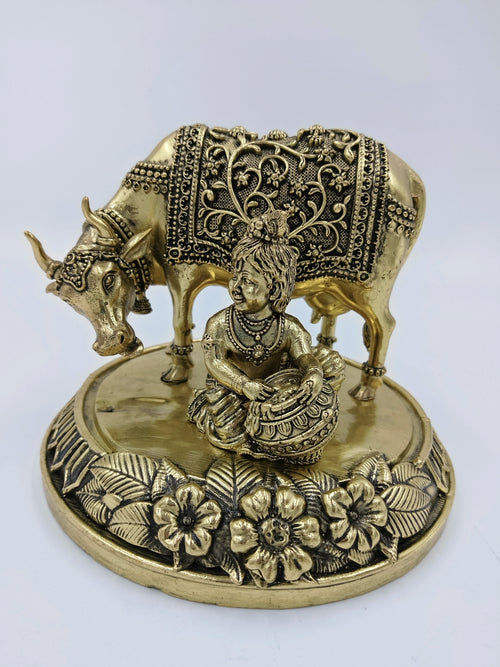 Brass statue of Krishna as child Gau Gopal with cow on floral base