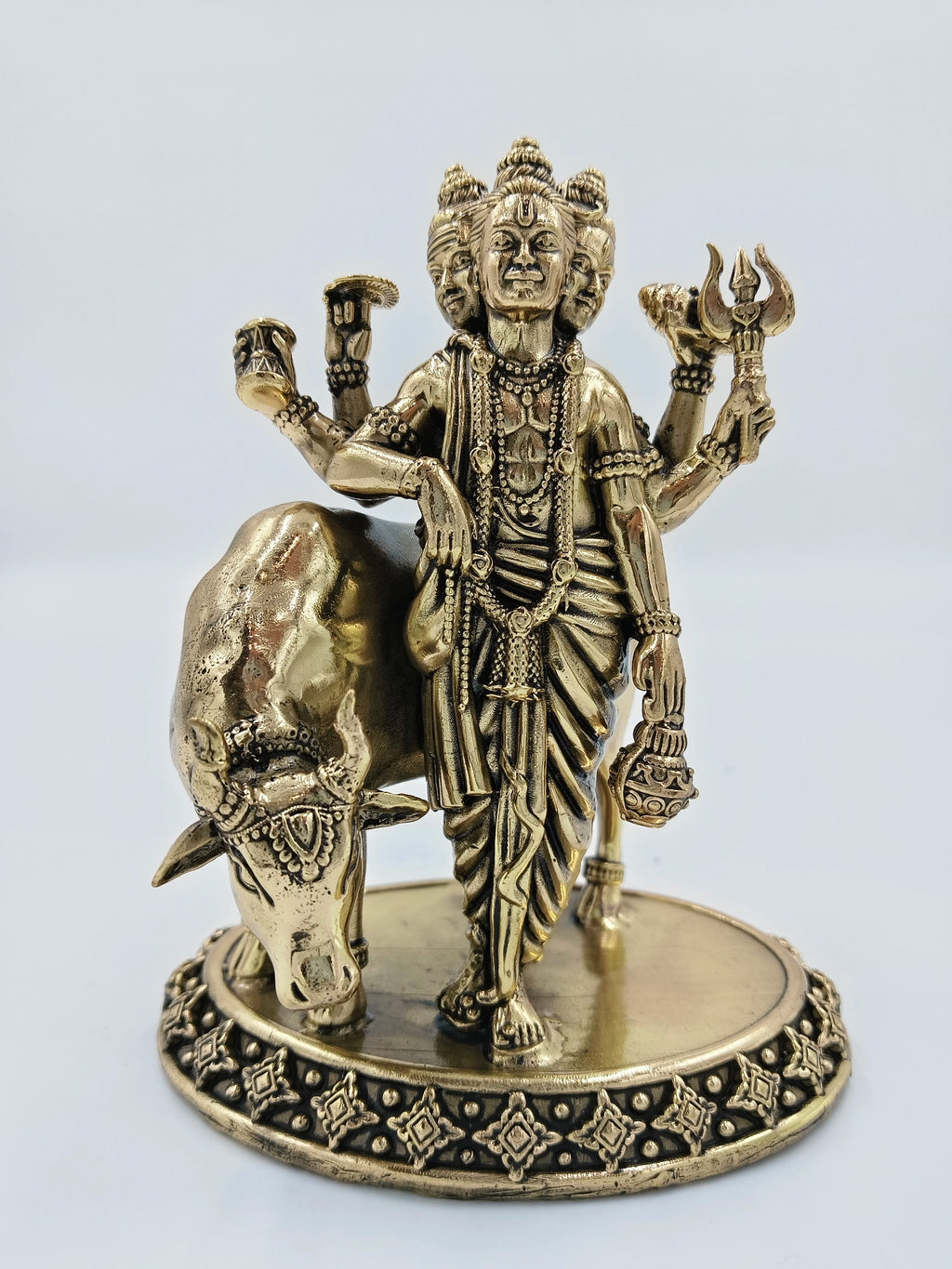 Medium brass statue of Hindu deity Dattatreya with cow on decorative base