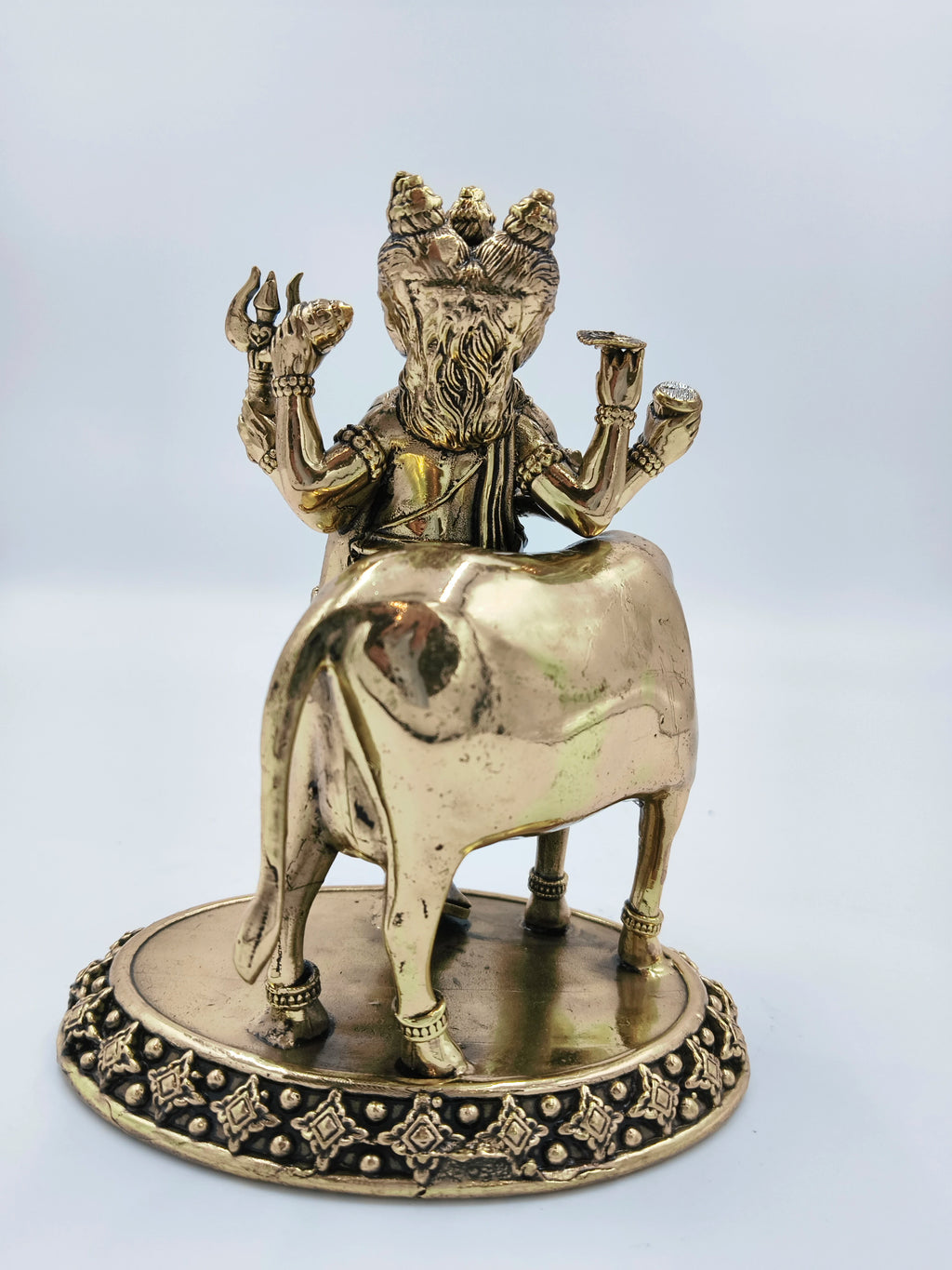 Rear view of medium brass Dattatreya statue with cow on decorative base