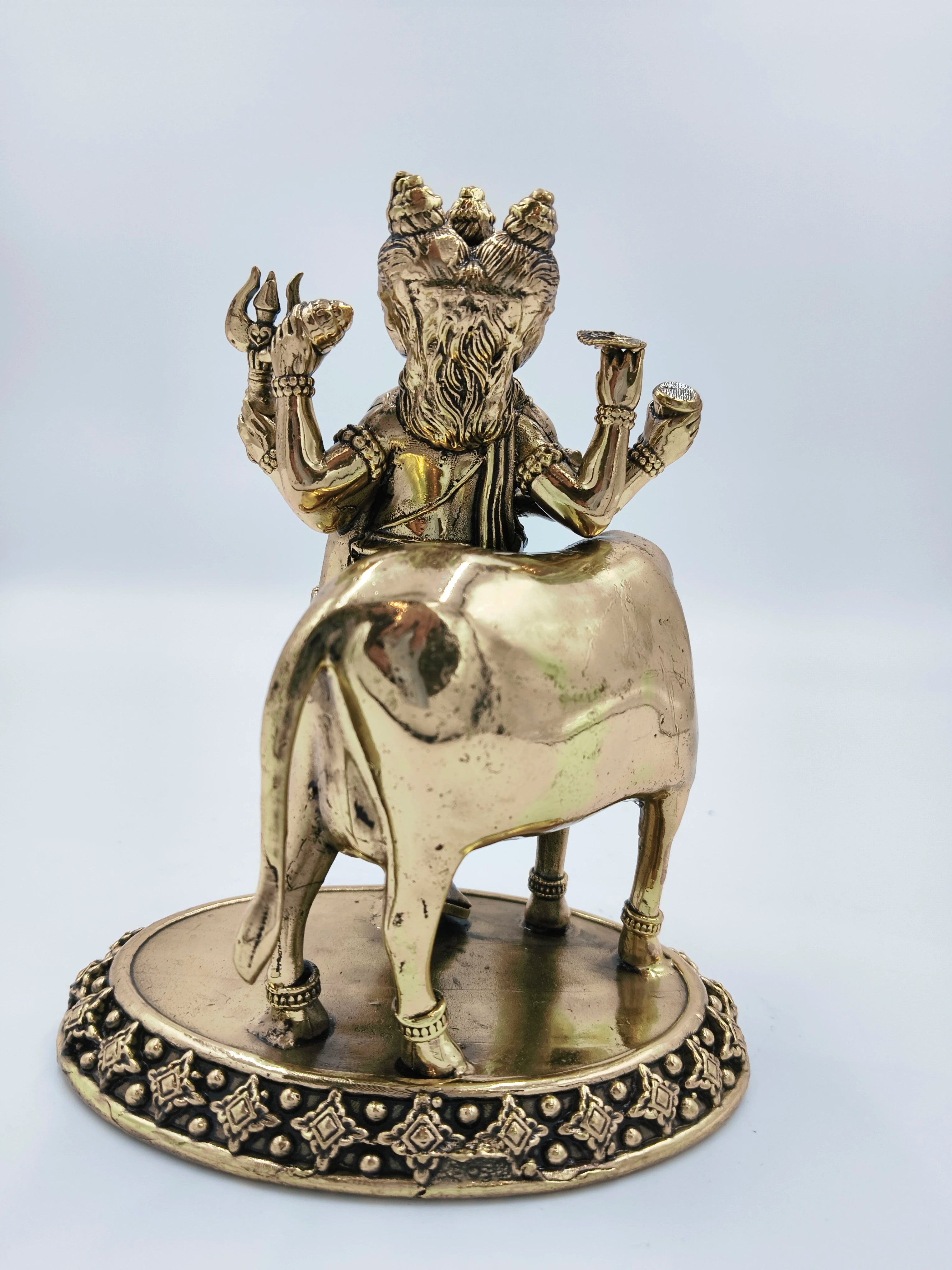 Rear view of medium brass Dattatreya statue with cow on decorative base