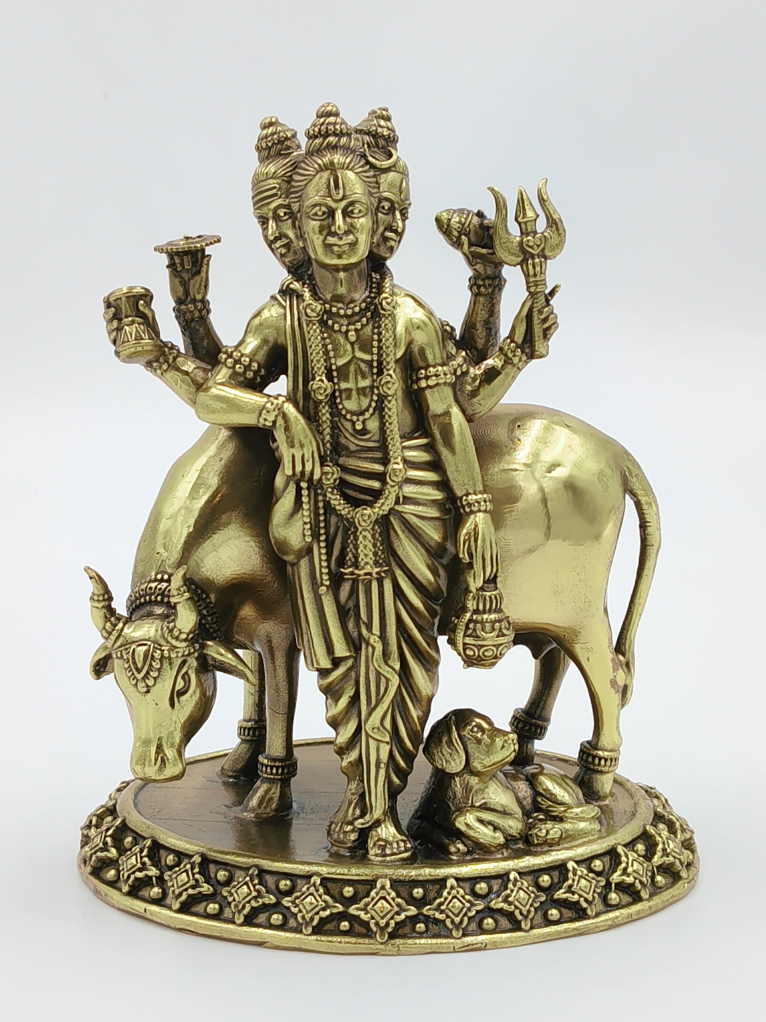 Brass sculpture of Dattatreya with three heads, cow, and dog on decorative base