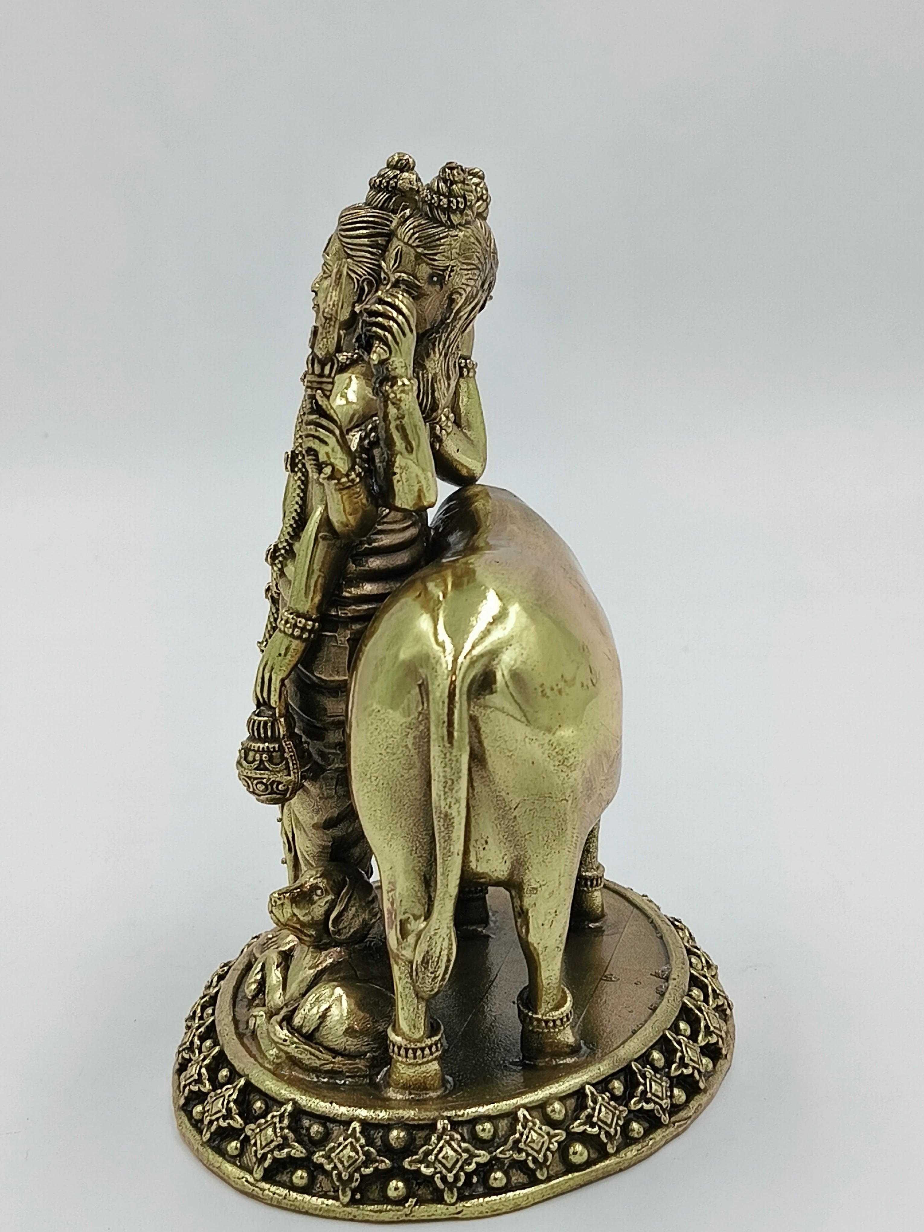 Brass sculpture of three-headed Dattatreya with a cow and dog on detailed base, back view