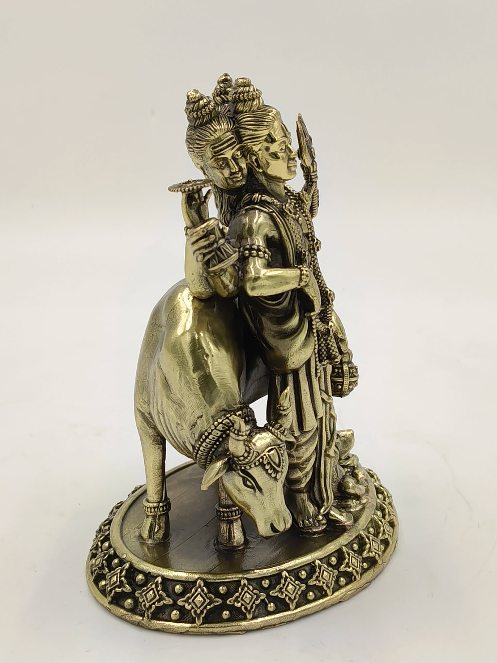 Brass statue of Dattatreya with three heads and a cow on decorative base