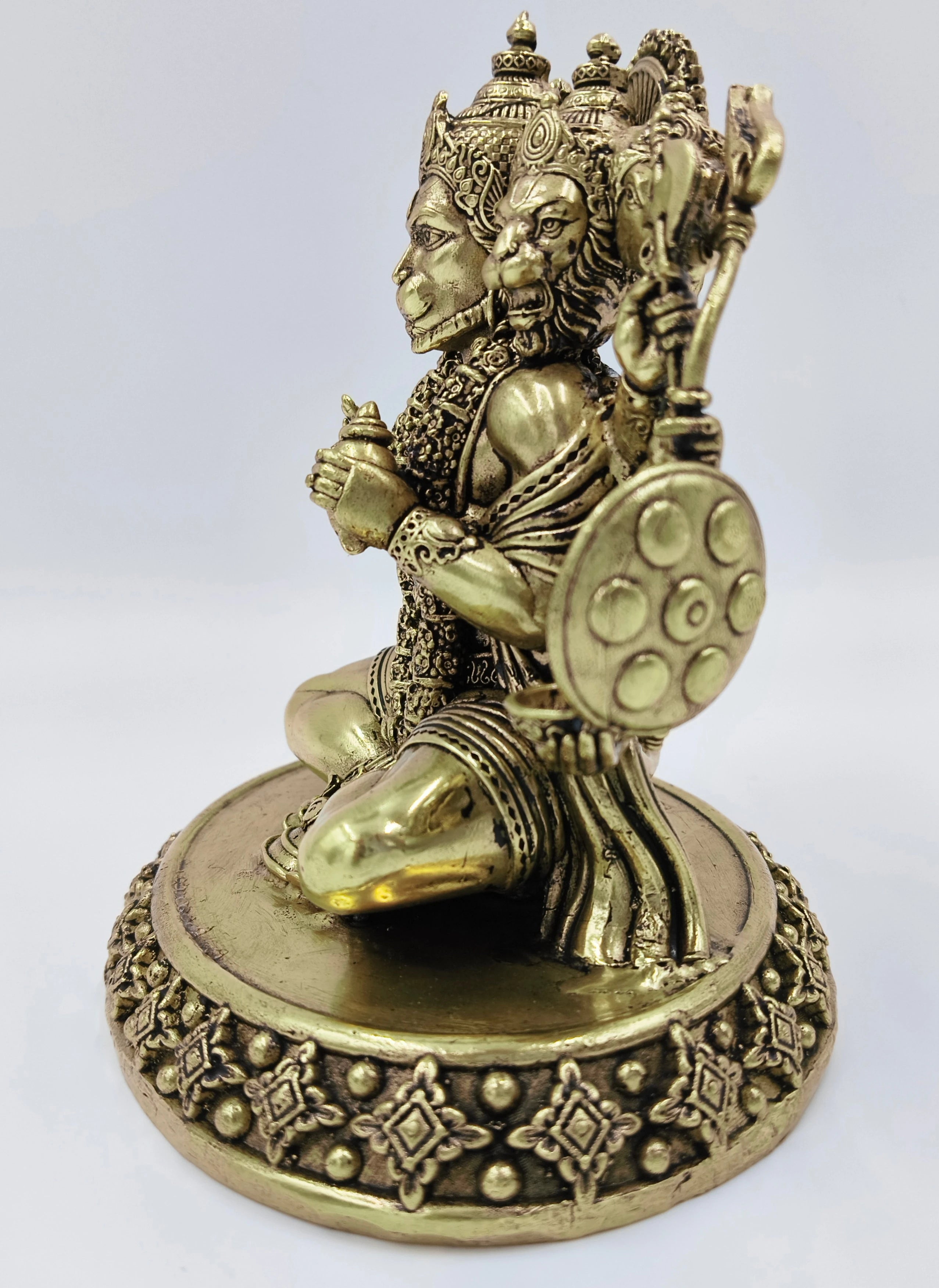Side view of brass Panchamukhi Hanuman statue sitting on ornamental base