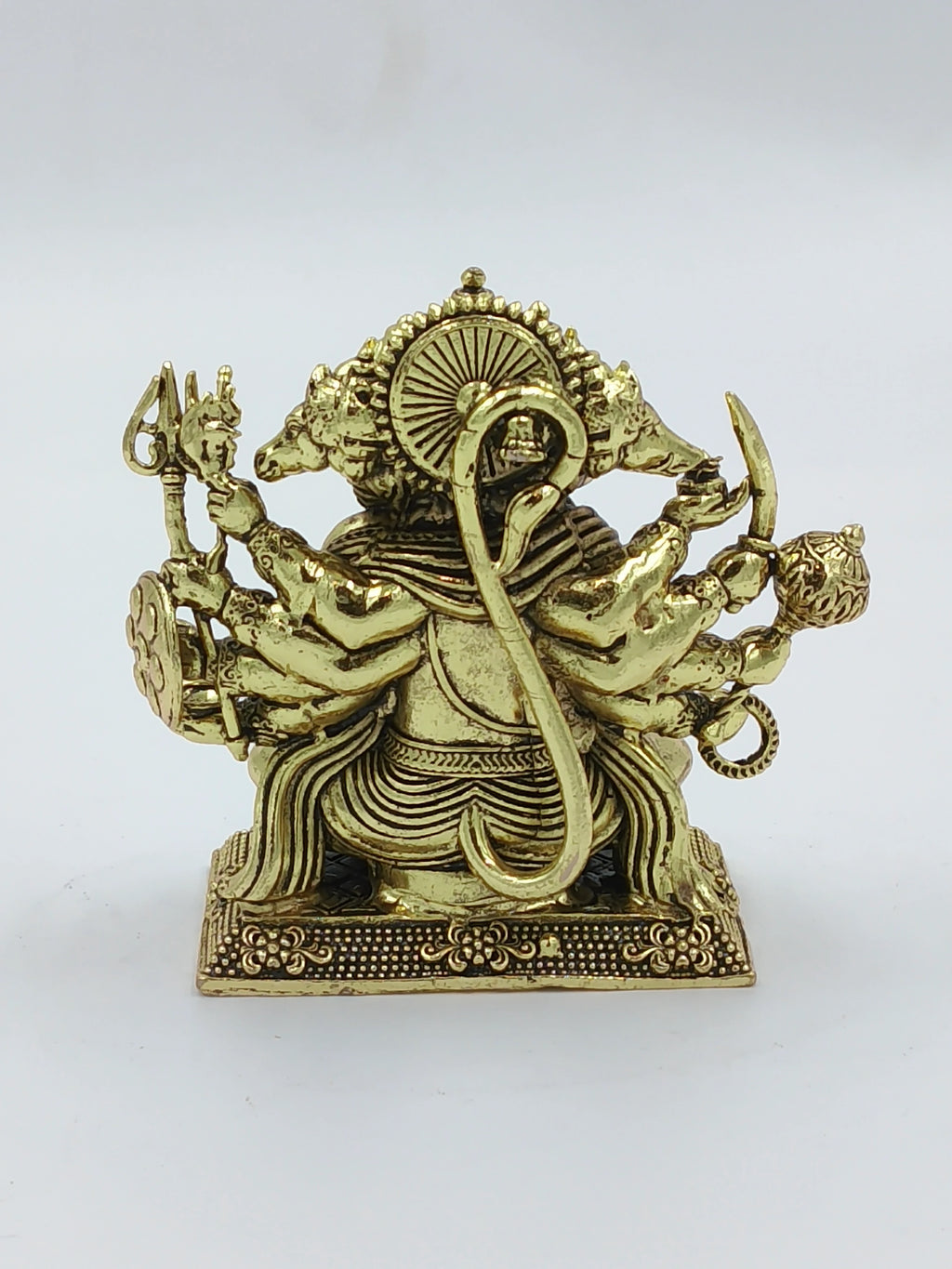 Back view of a small brass Panchamukhi Hanuman statue with five faces and multiple arms