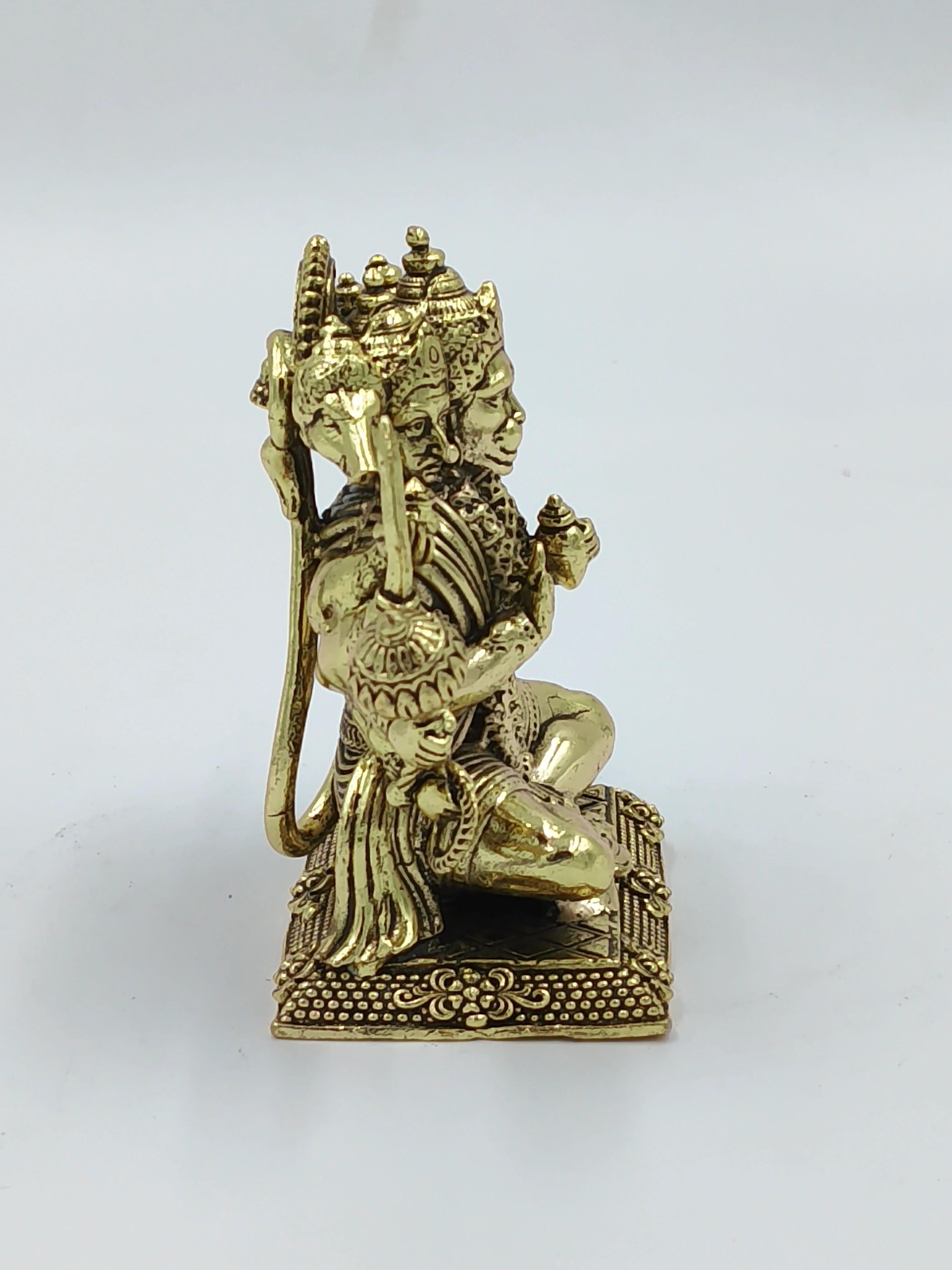 Small brass Panchamukhi Hanuman statue sitting on a decorative base side view