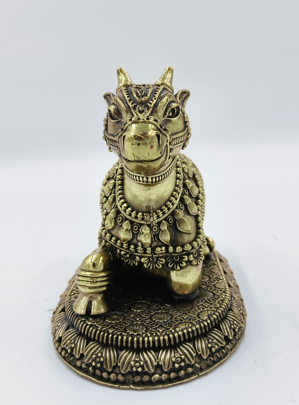 Small brass sculpture of Nandikeshwara bull adorned with decorative engravings