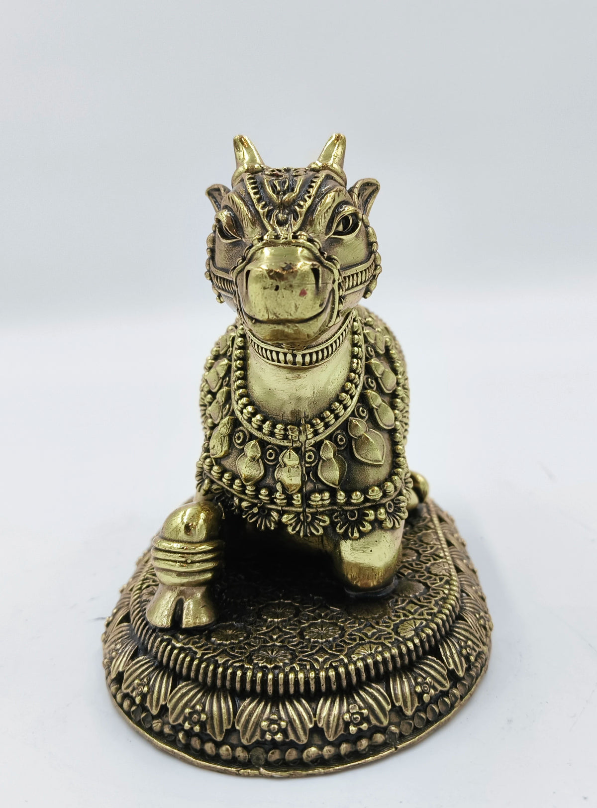 Small brass sculpture of Nandikeshwara bull adorned with decorative engravings