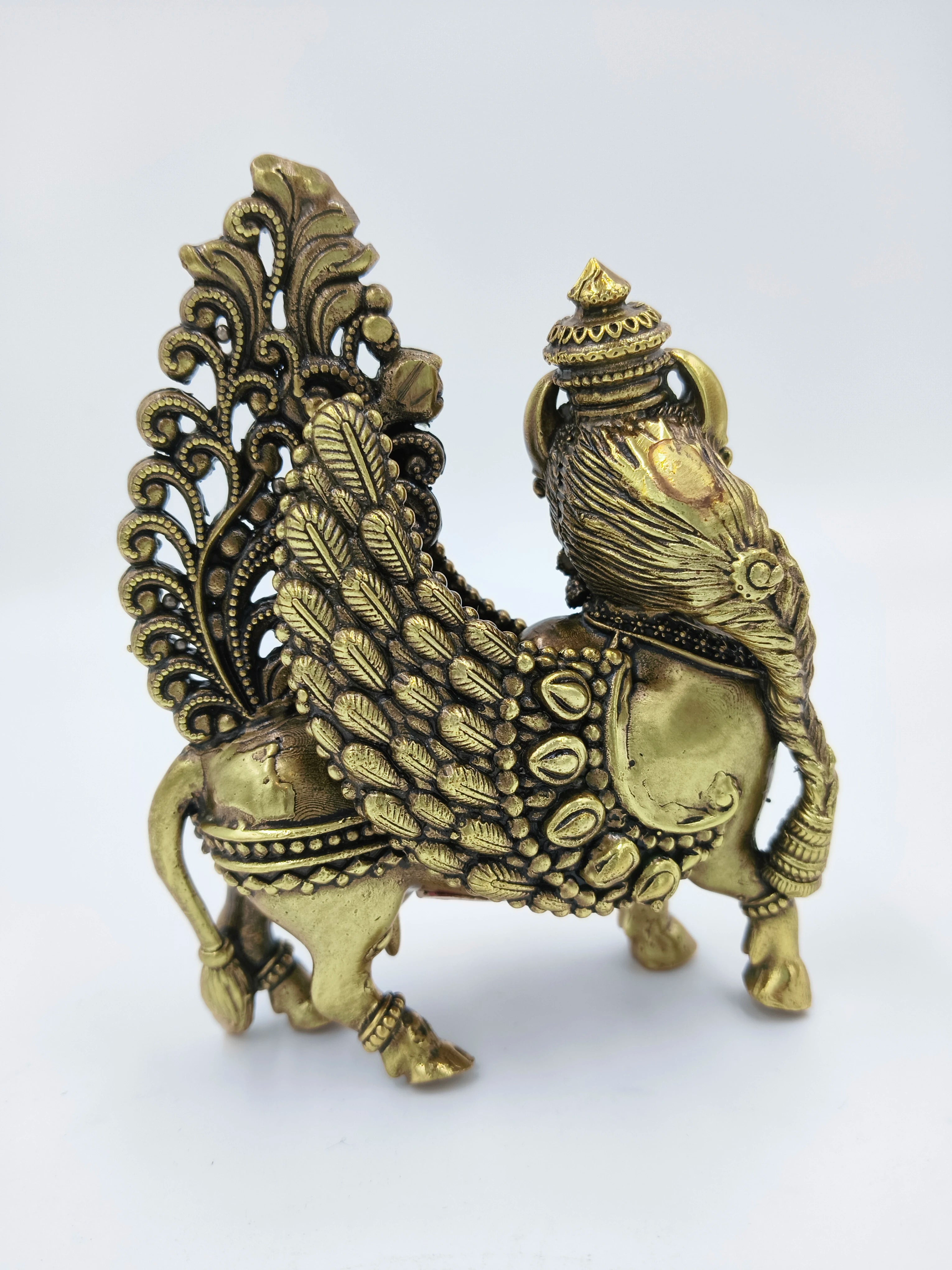 Brass Kamadhenu sculpture with detailed wings and decorative elements side view