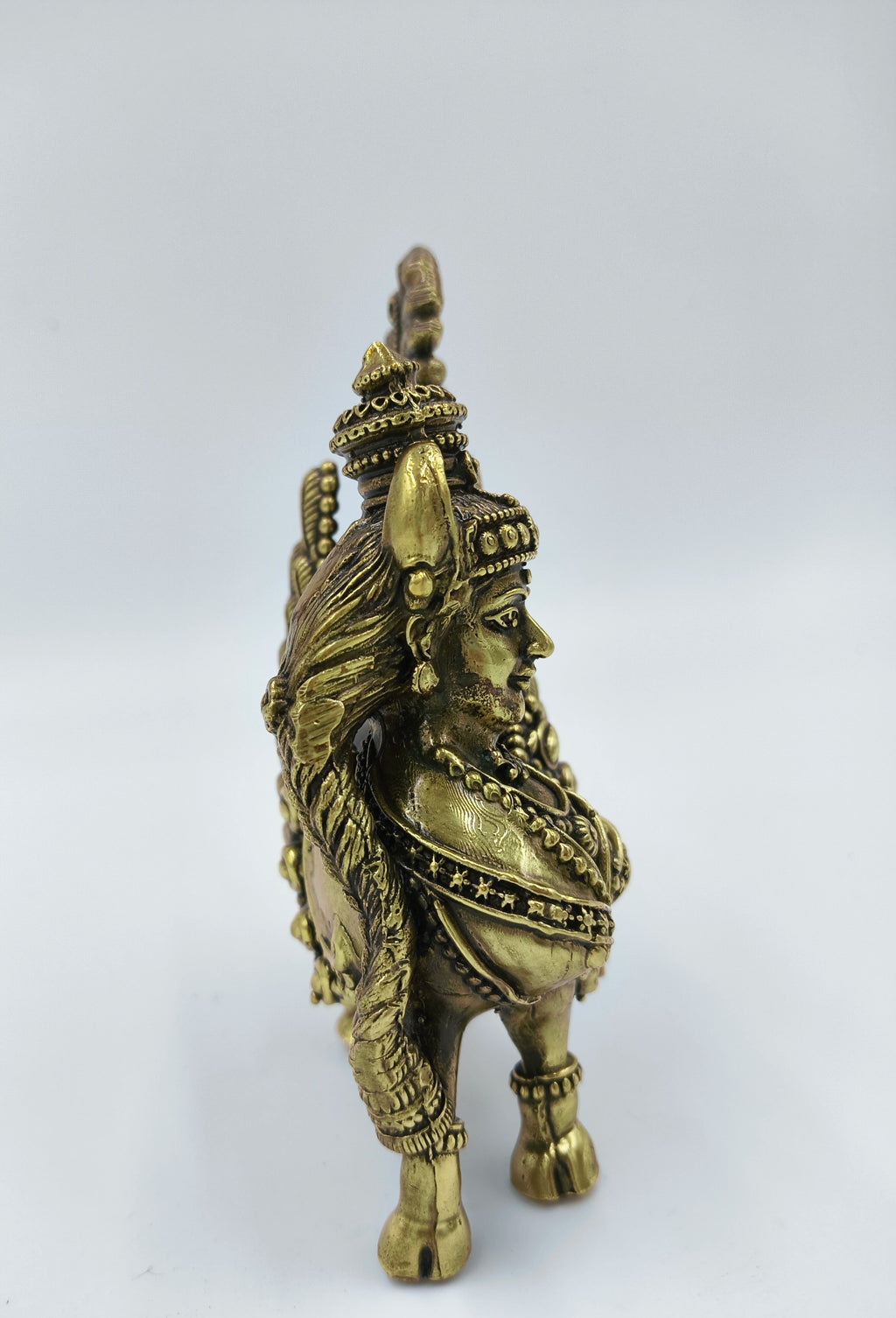 Side view of medium brass Kamadhenu statue with detailed jewelry and ornaments