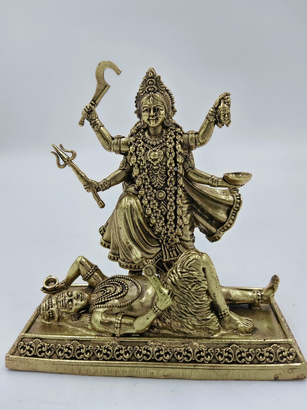 Small brass sculpture of goddess Kalika standing on a demon figure