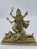 Small brass sculpture of goddess Kalika standing on a demon figure