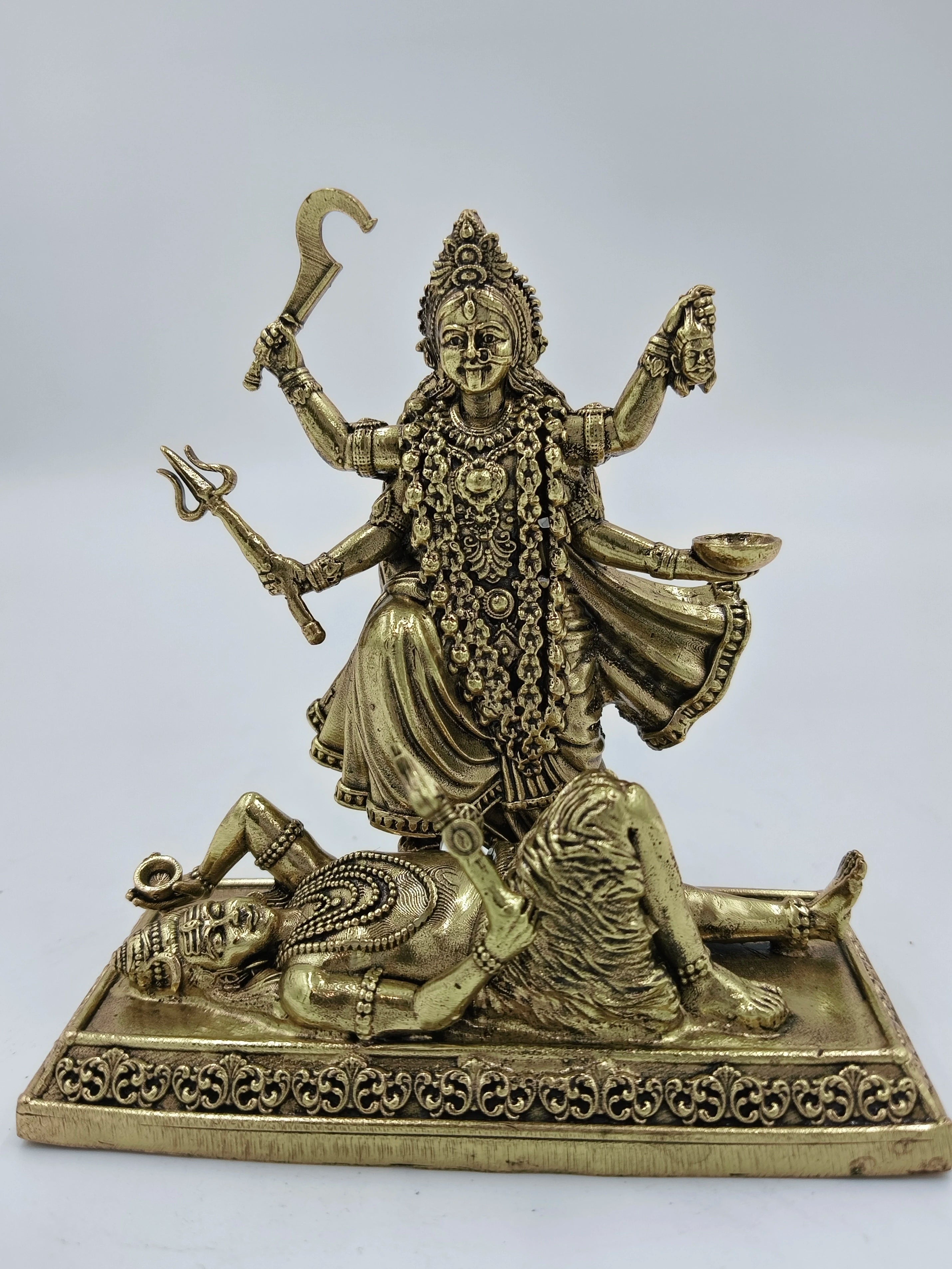 Small brass sculpture of goddess Kalika standing on a demon figure