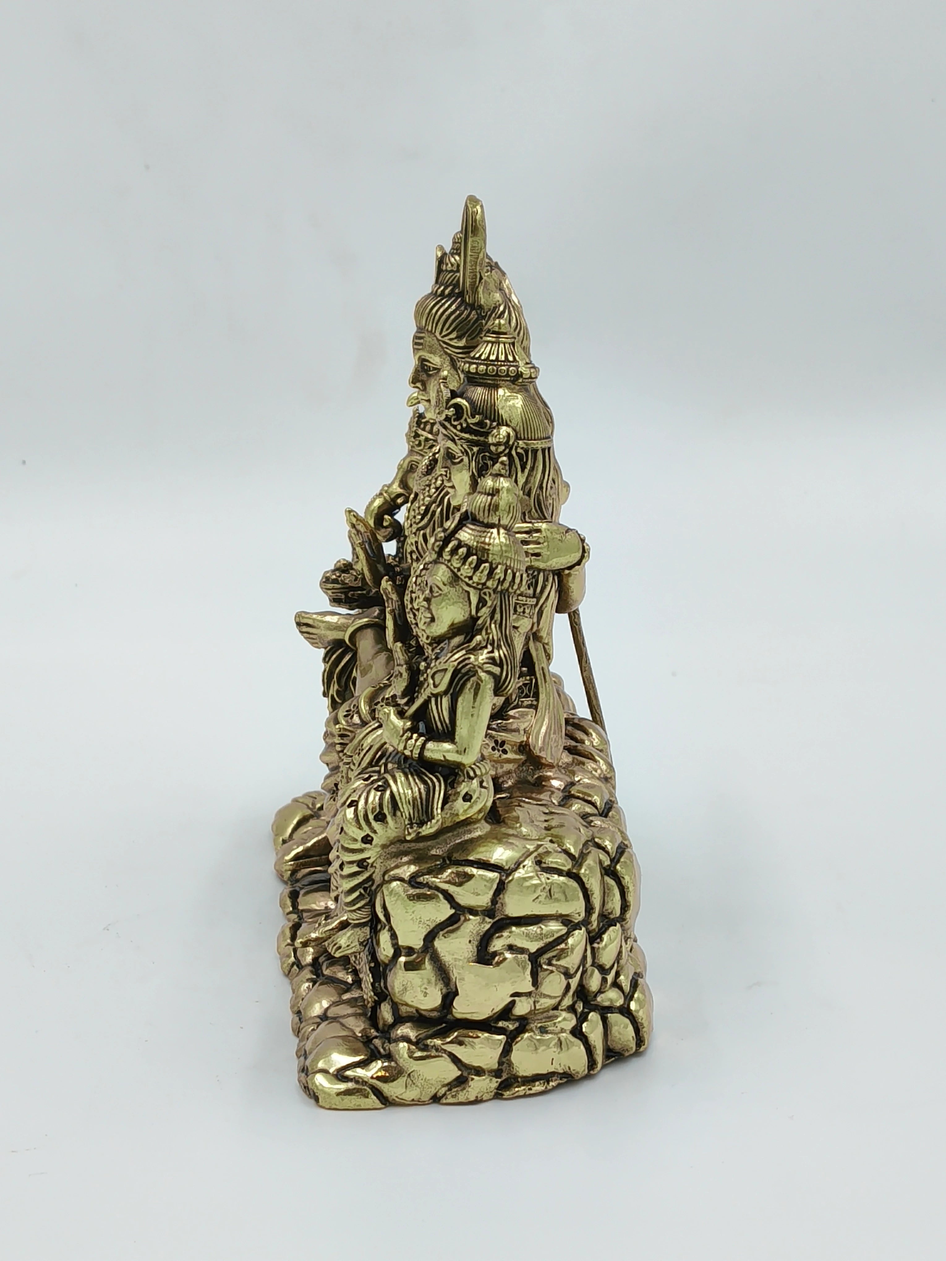 Side view of brass Shiv Parivar sculpture seated on a detailed rock base