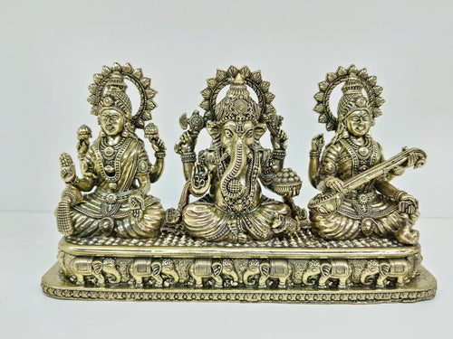 Small brass tabletop statue of Lakshmi, Ganesh, and Saraswathi with elephant motifs