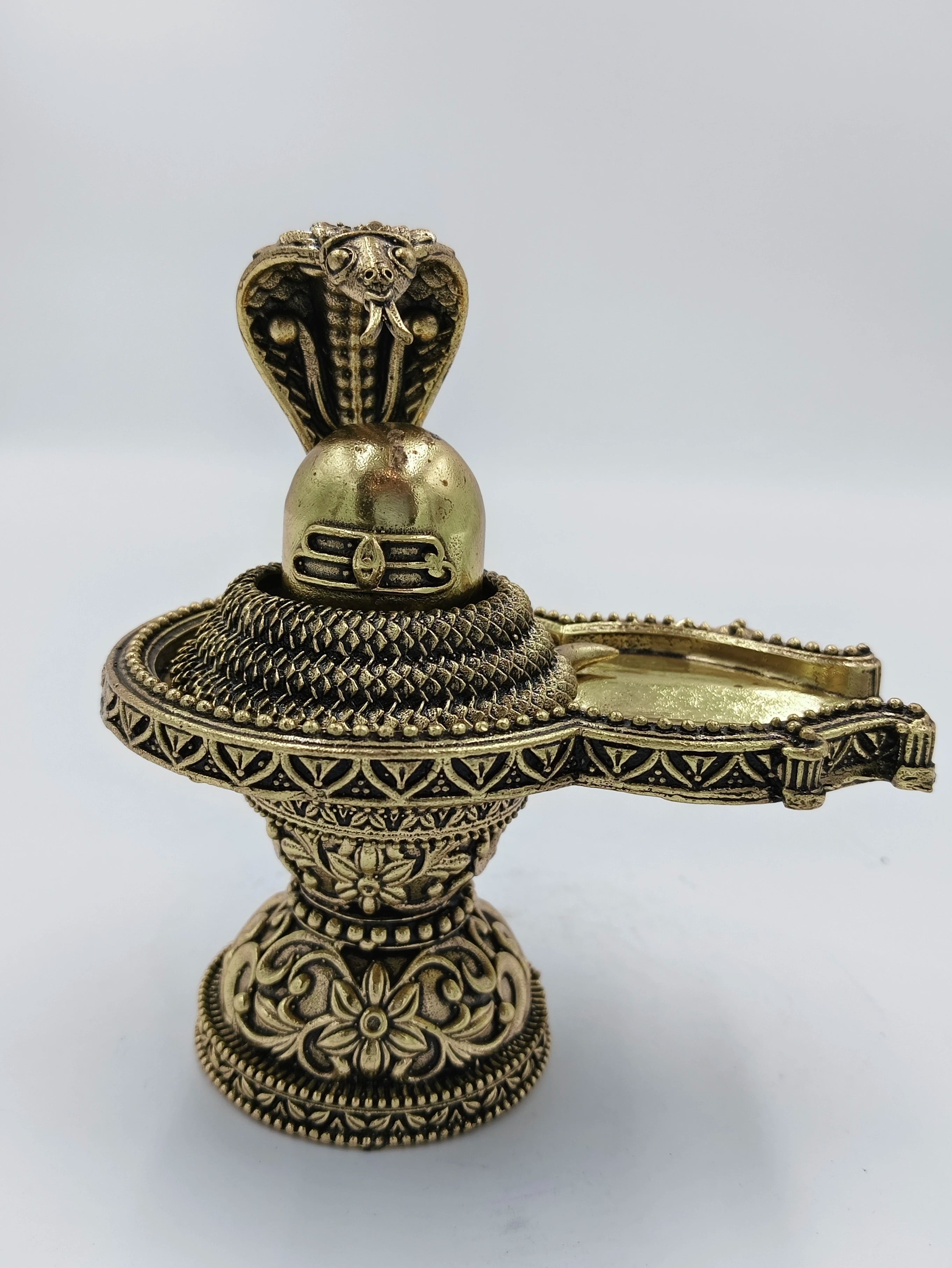 Medium brass Shivalinga sculpture with snake hood and intricate floral base