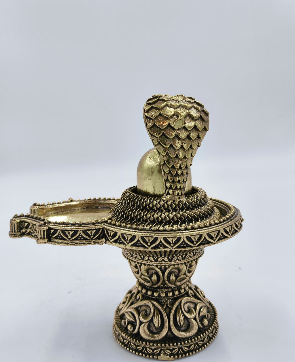 Medium brass Shivalinga sculpture with ornate base and serpent hood detail side view