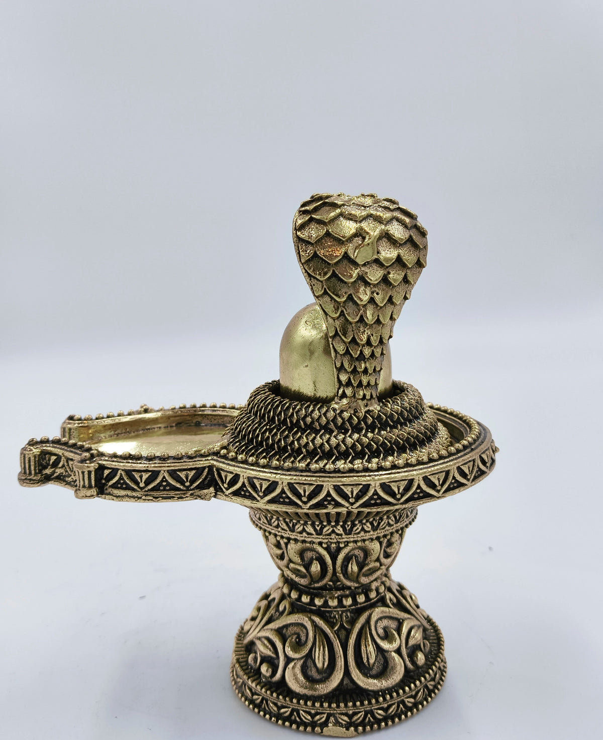 Medium brass Shivalinga sculpture with ornate base and serpent hood detail side view