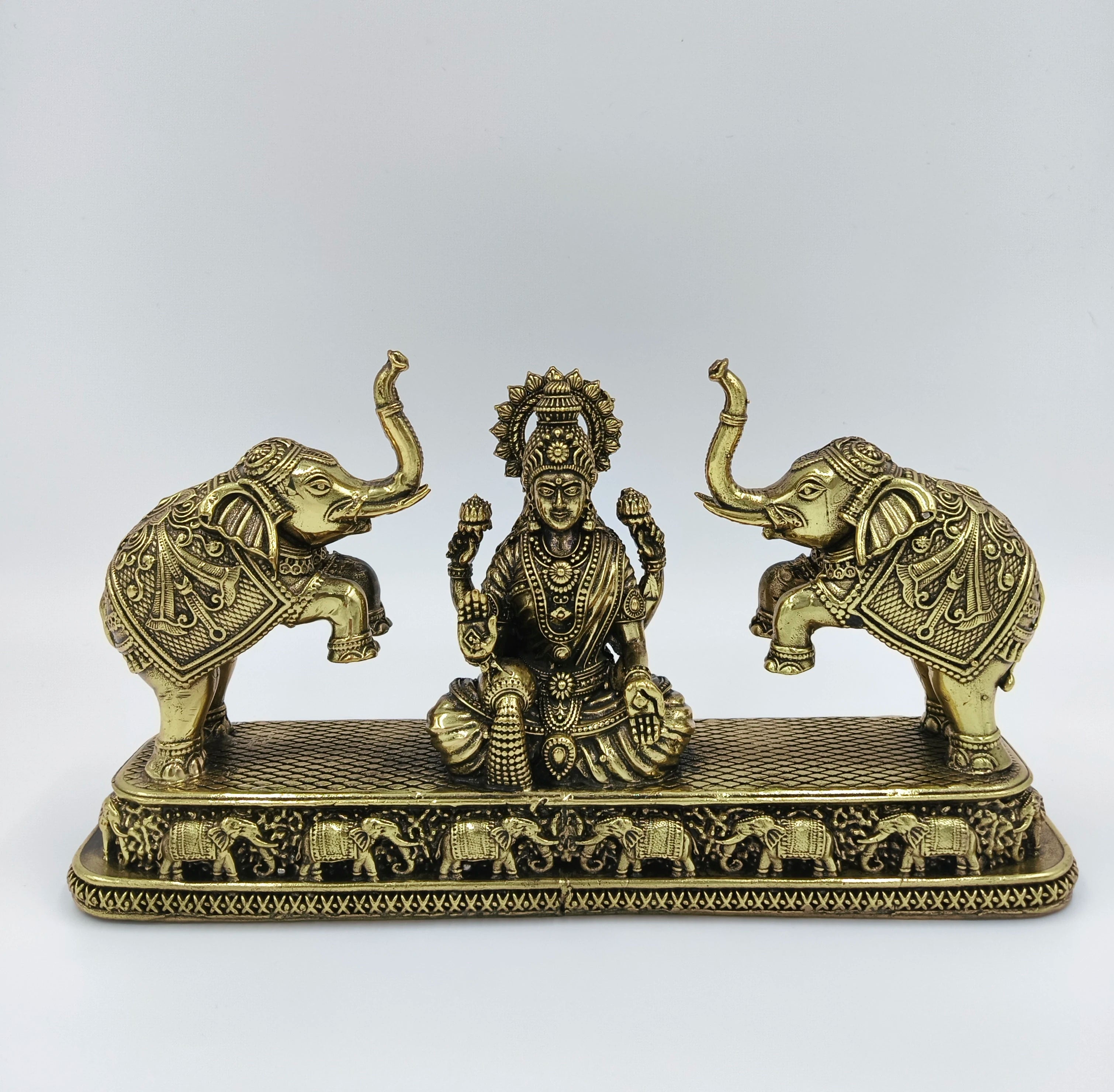 Brass Gajalakshmi sculpture with Lakshmi deity flanked by two elephants on a decorative base
