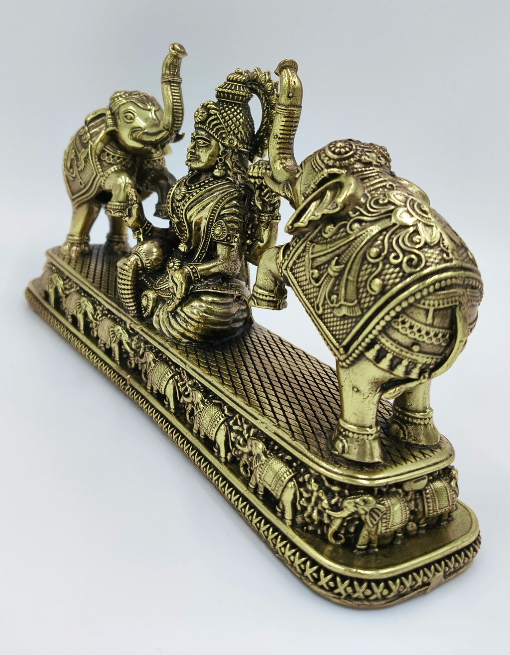 Brass Gajalakshmi statue with detailed elephants on a decorative base, side view