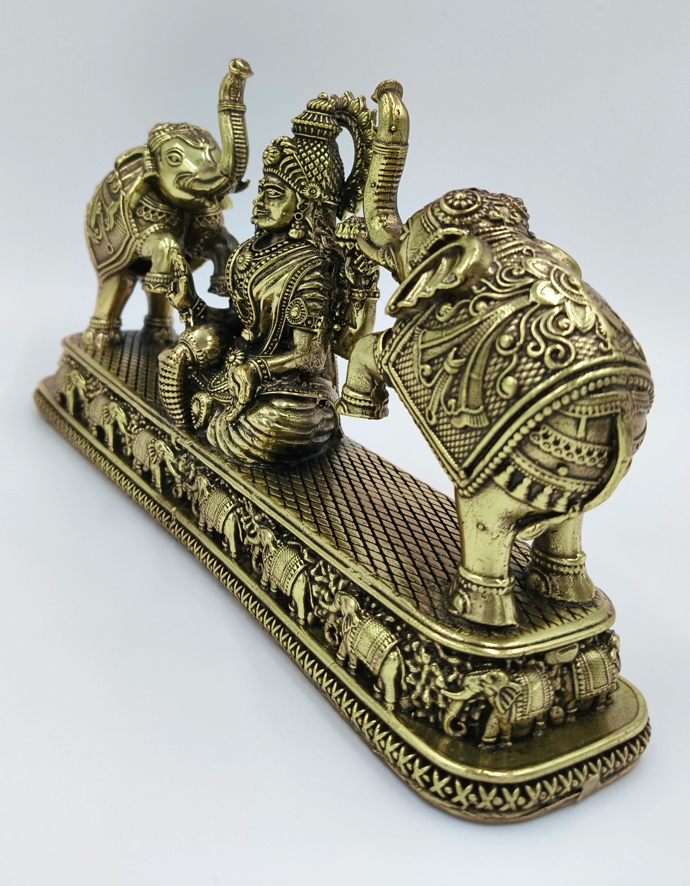 Brass Gajalakshmi statue with detailed elephants on a decorative base, side view