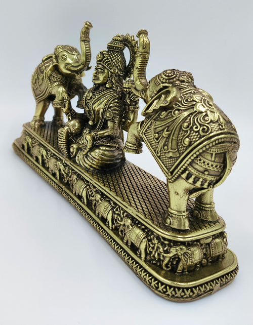 Brass Gajalakshmi statue with detailed elephants on a decorative base, side view