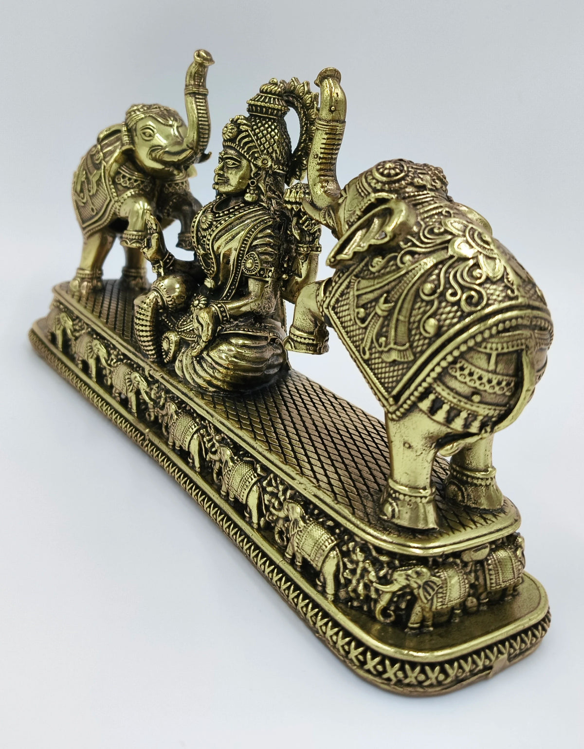 Brass Gajalakshmi statue with detailed elephants on a decorative base, side view