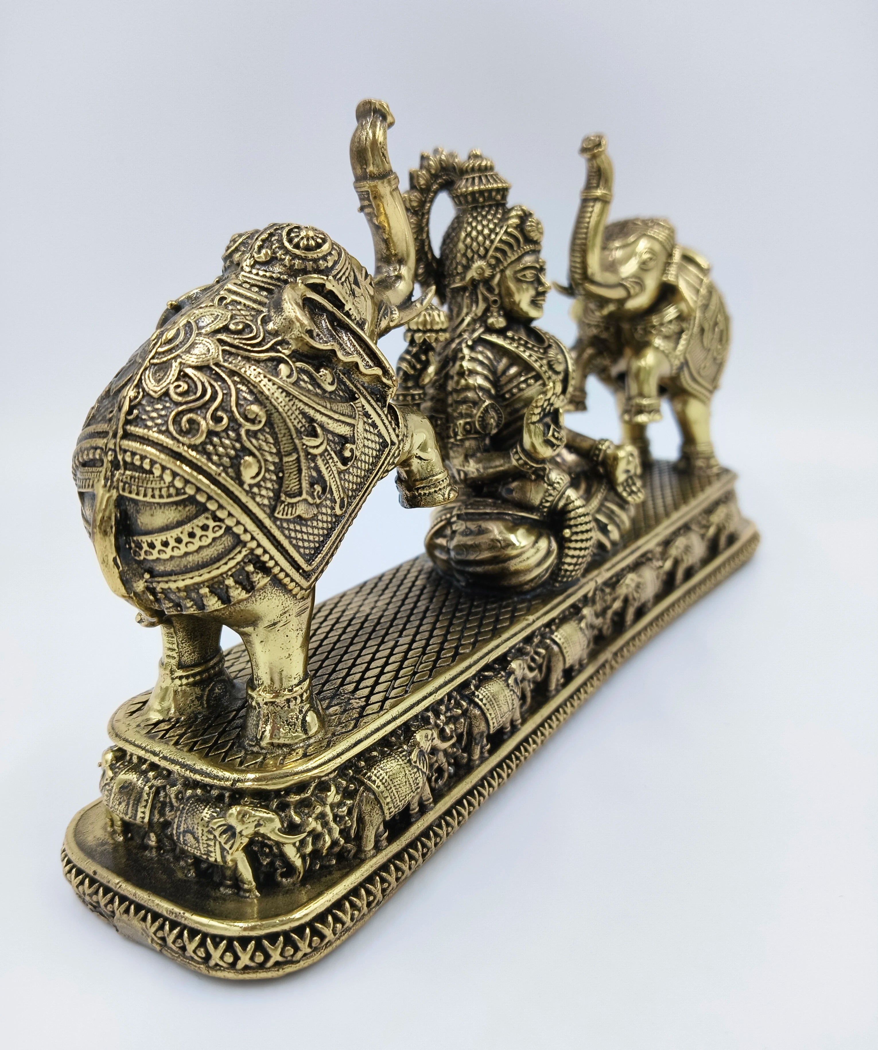 Brass Gajalakshmi sculpture showing goddess Lakshmi flanked by two decorated elephants on an ornate base