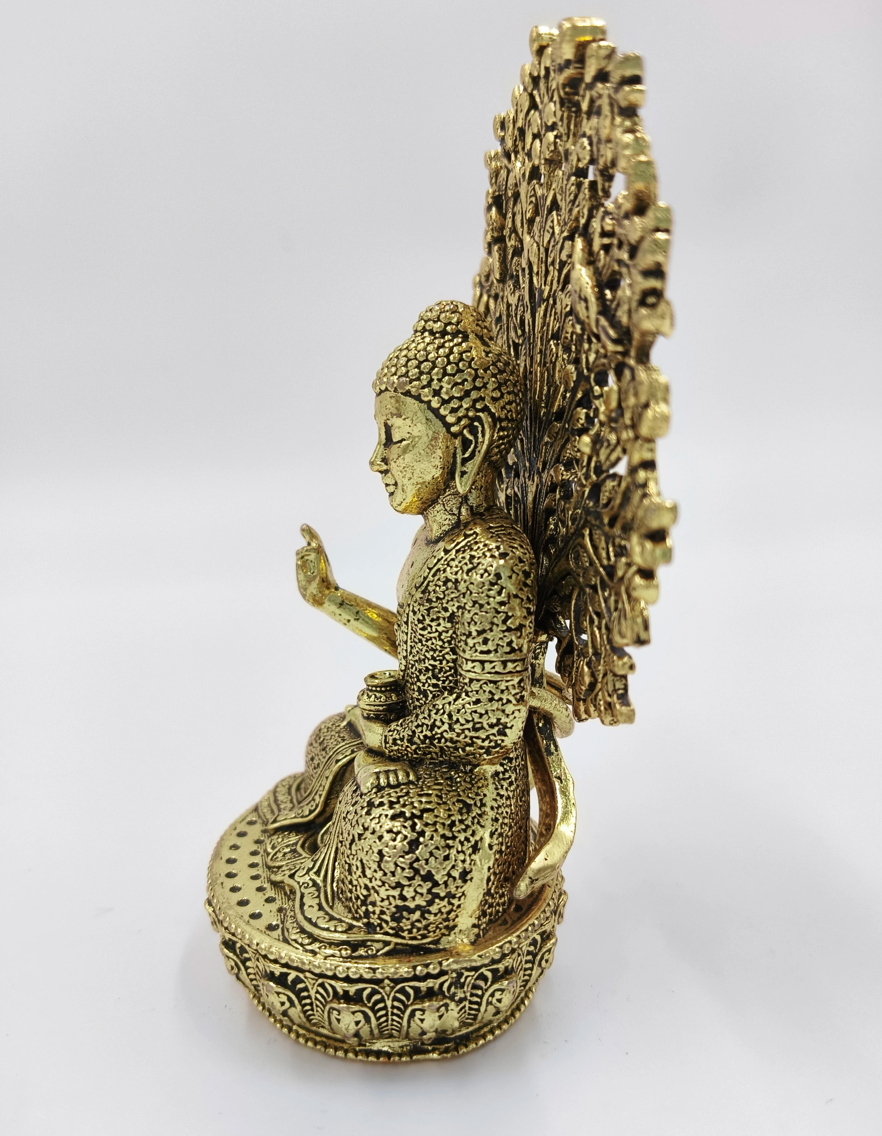 Small brass Buddha statue with intricate floral patterns and ornate round fan back