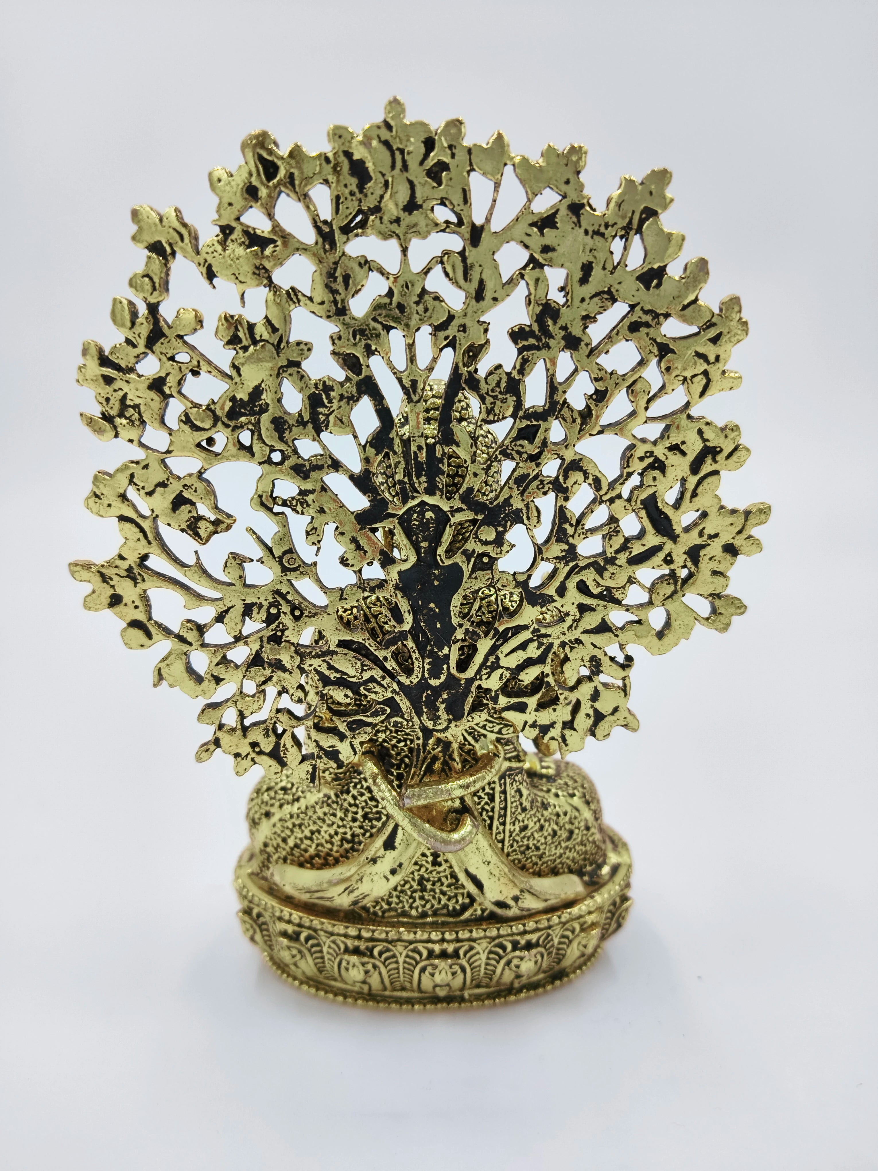 small brass Buddha figurine seated with detailed ornamental backdrop