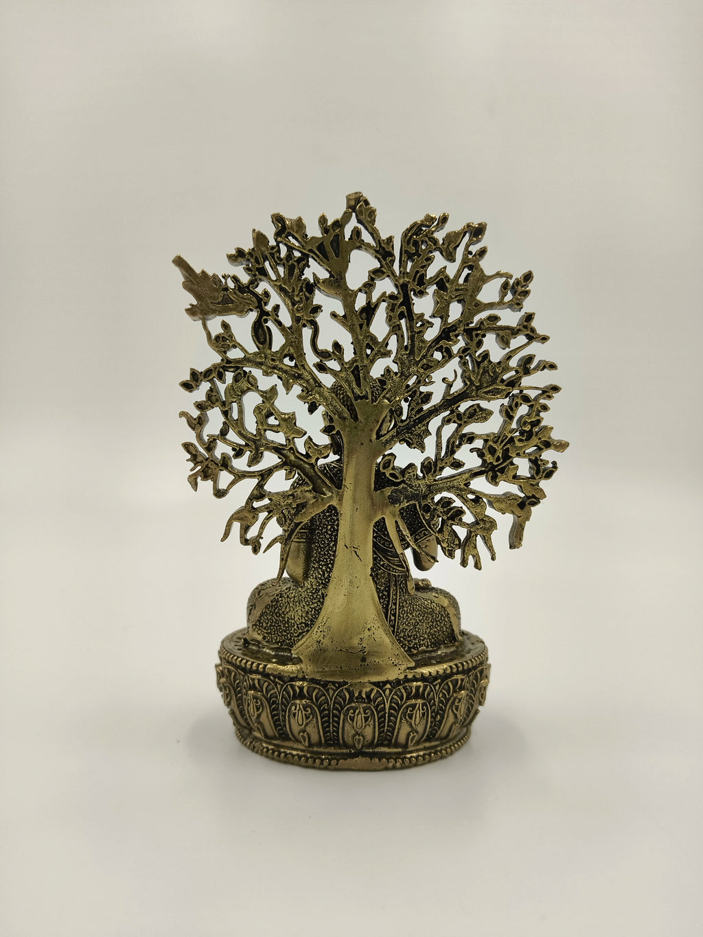 Brass Buddha sculpture seated under a detailed Bodhi tree on decorative base