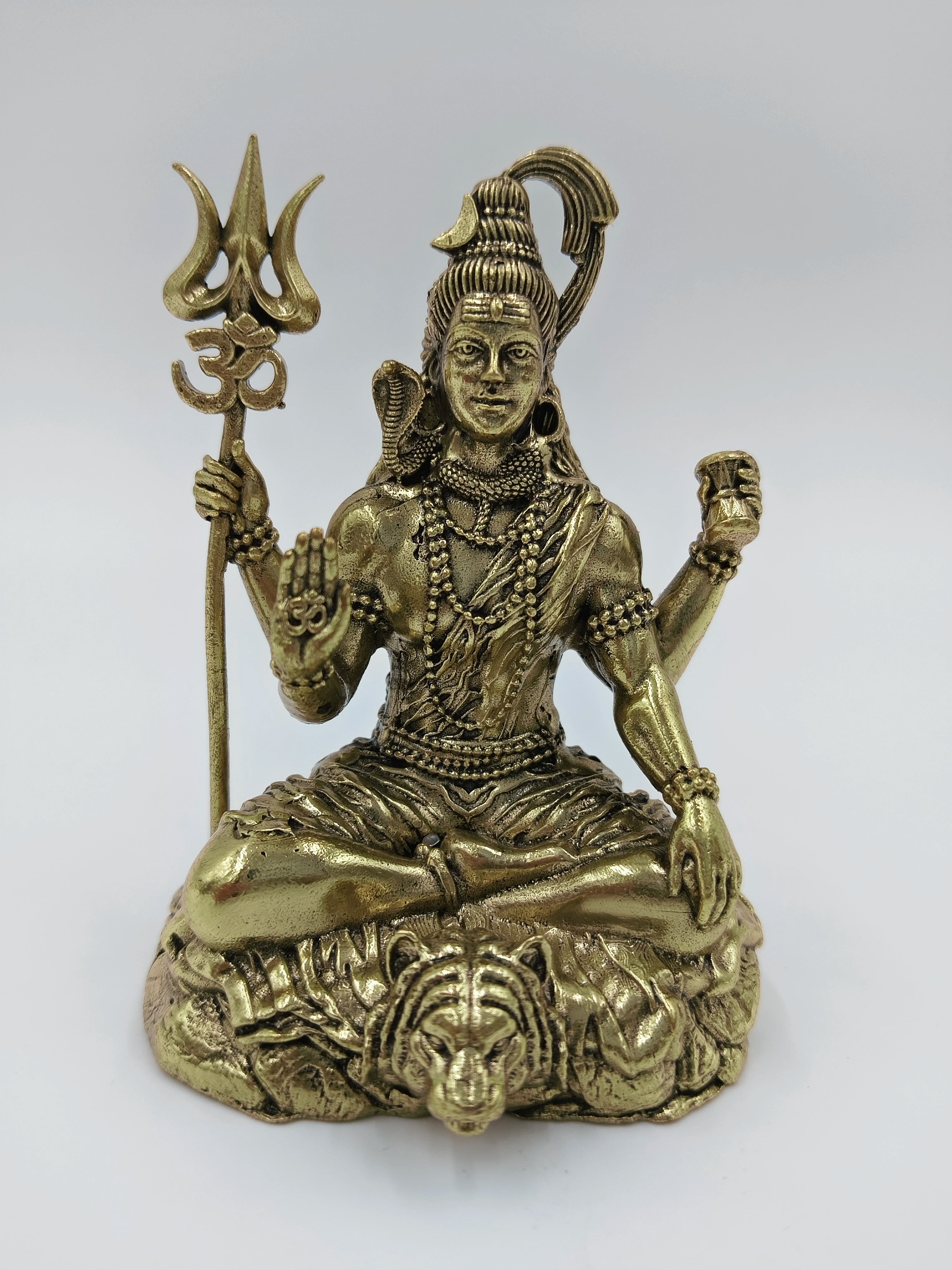 Small brass sculpture of Shiva seated in lotus pose holding trident and drum