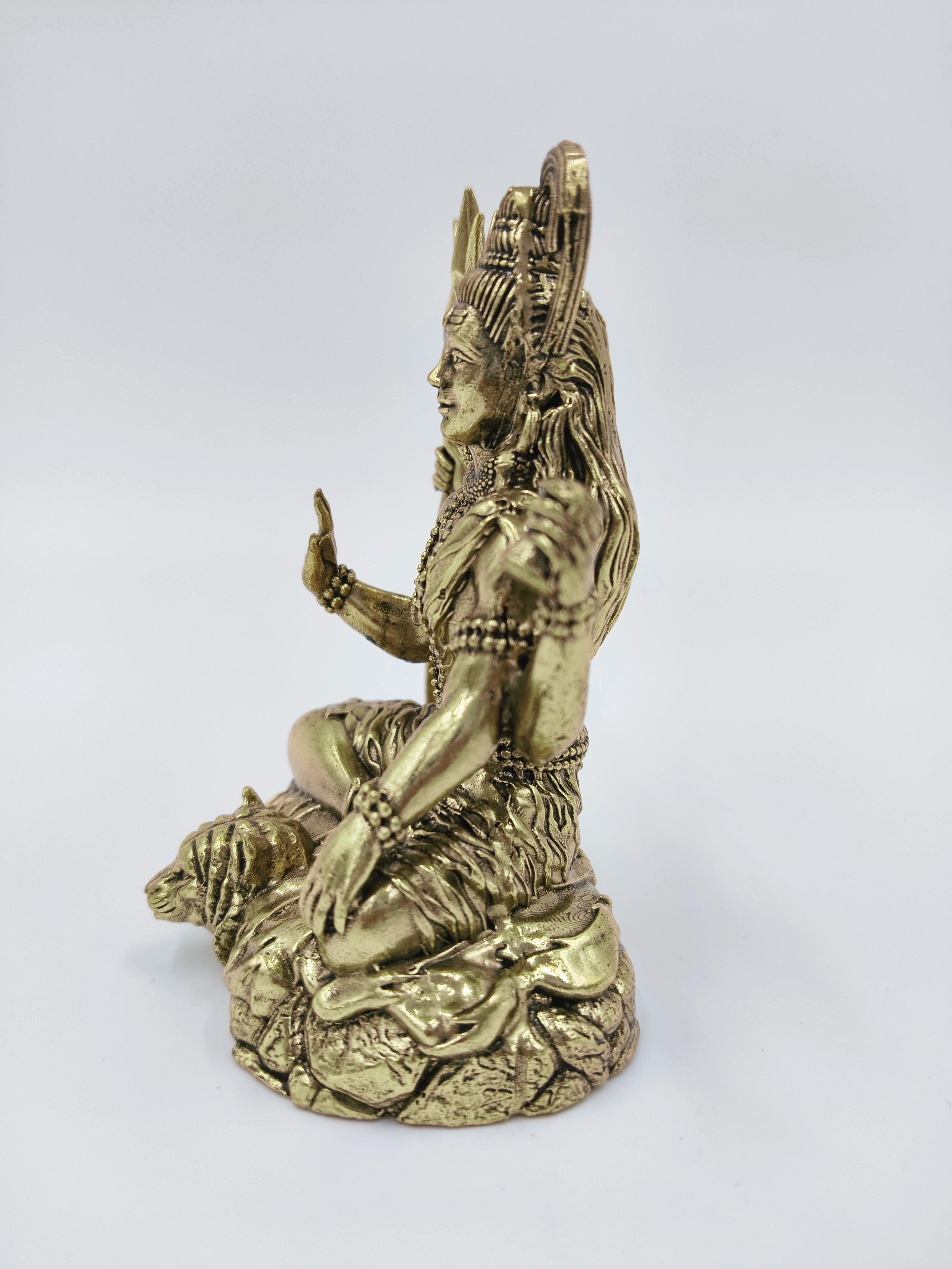 Small brass Mahadeva (Shiva) sculpture seated on textured base side view