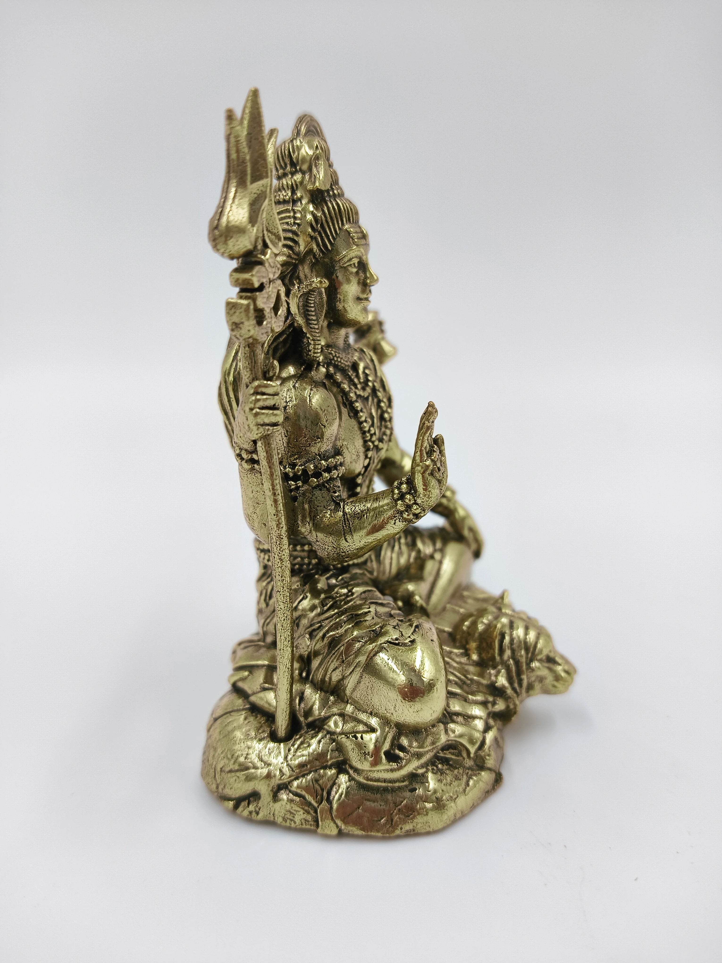 Side view of small brass Mahadeva (Shiva) sculpture seated on lotus base
