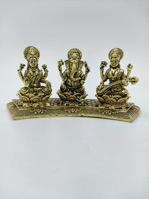 Mini brass statue featuring Lakshmi, Ganesh, and Saraswathi seated on a decorative base