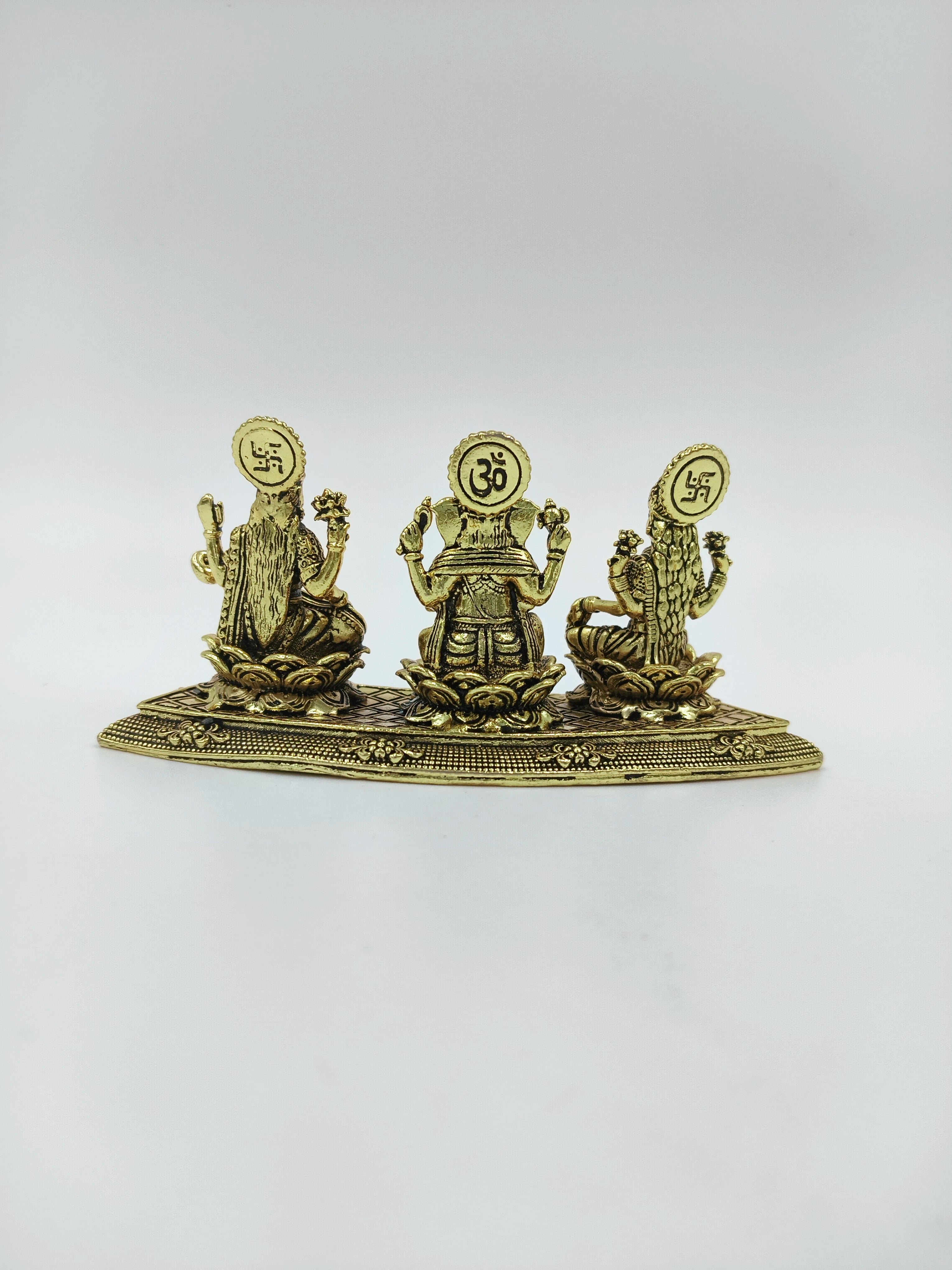Mini brass statue featuring deities Lakshmi, Ganesh, and Saraswathi from back view