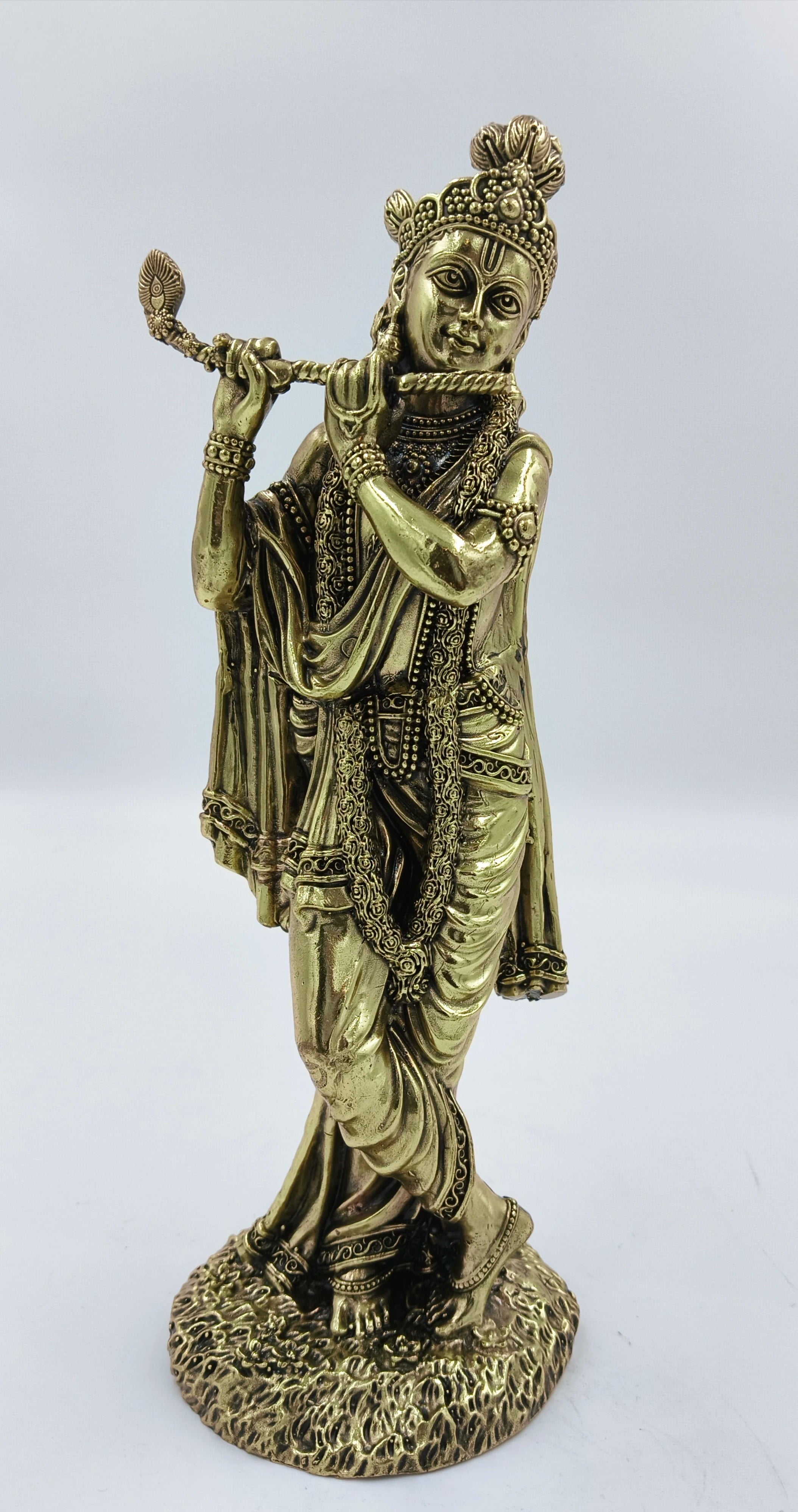 Large brass statue of Krishna playing flute with detailed ornamentation