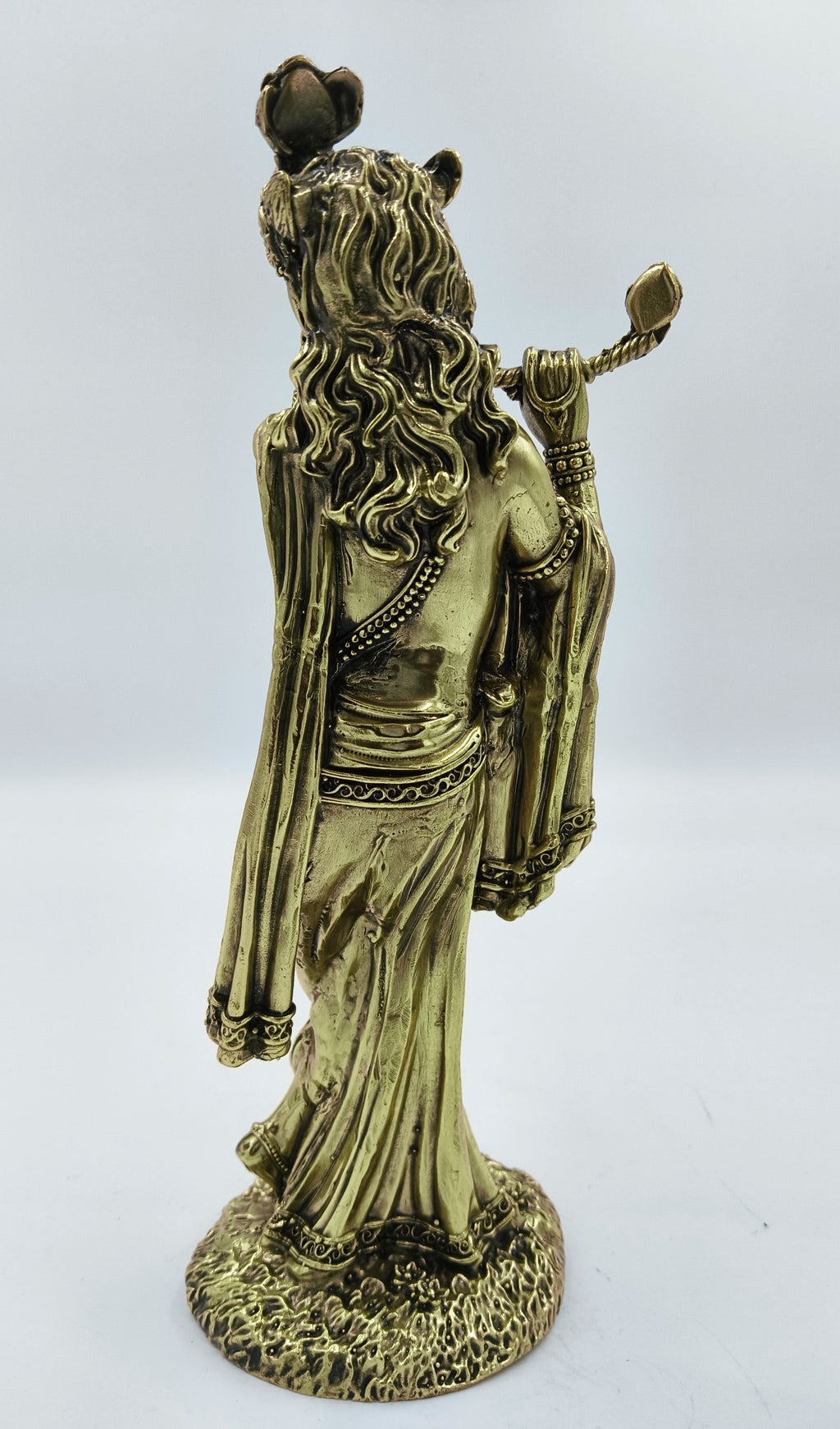 Back view of large brass Krishna sculpture with detailed hair and flute