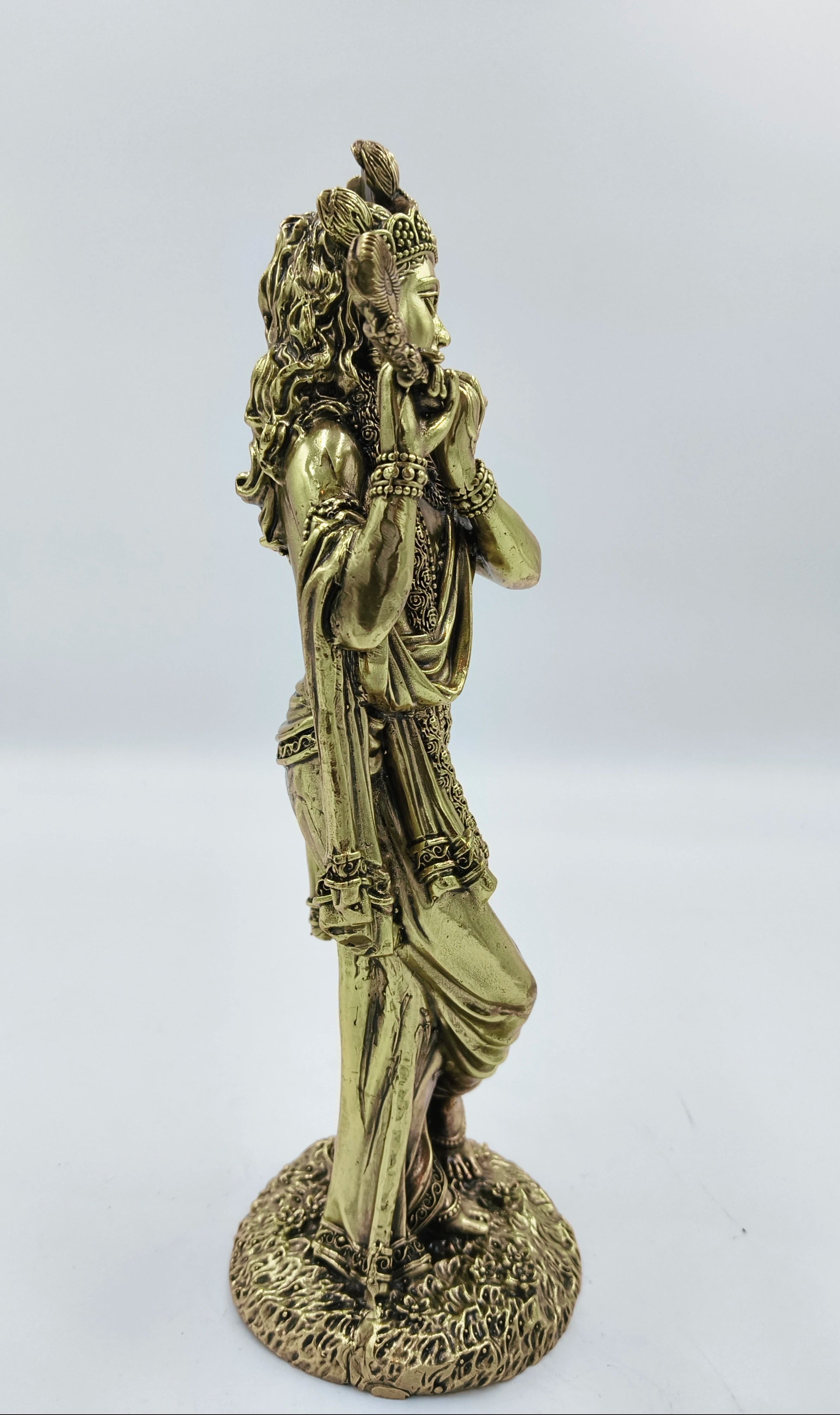 Side view brass statue of Achyuta Krishna playing a flute standing on ornate base