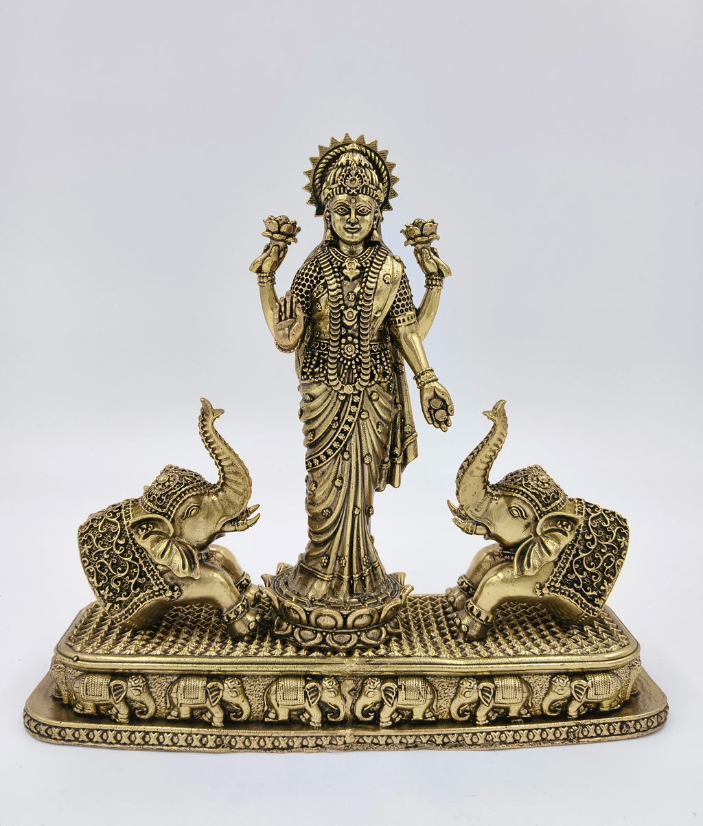 Large brass standing Gajalakshmi statue with two decorative elephants on rectangular base
