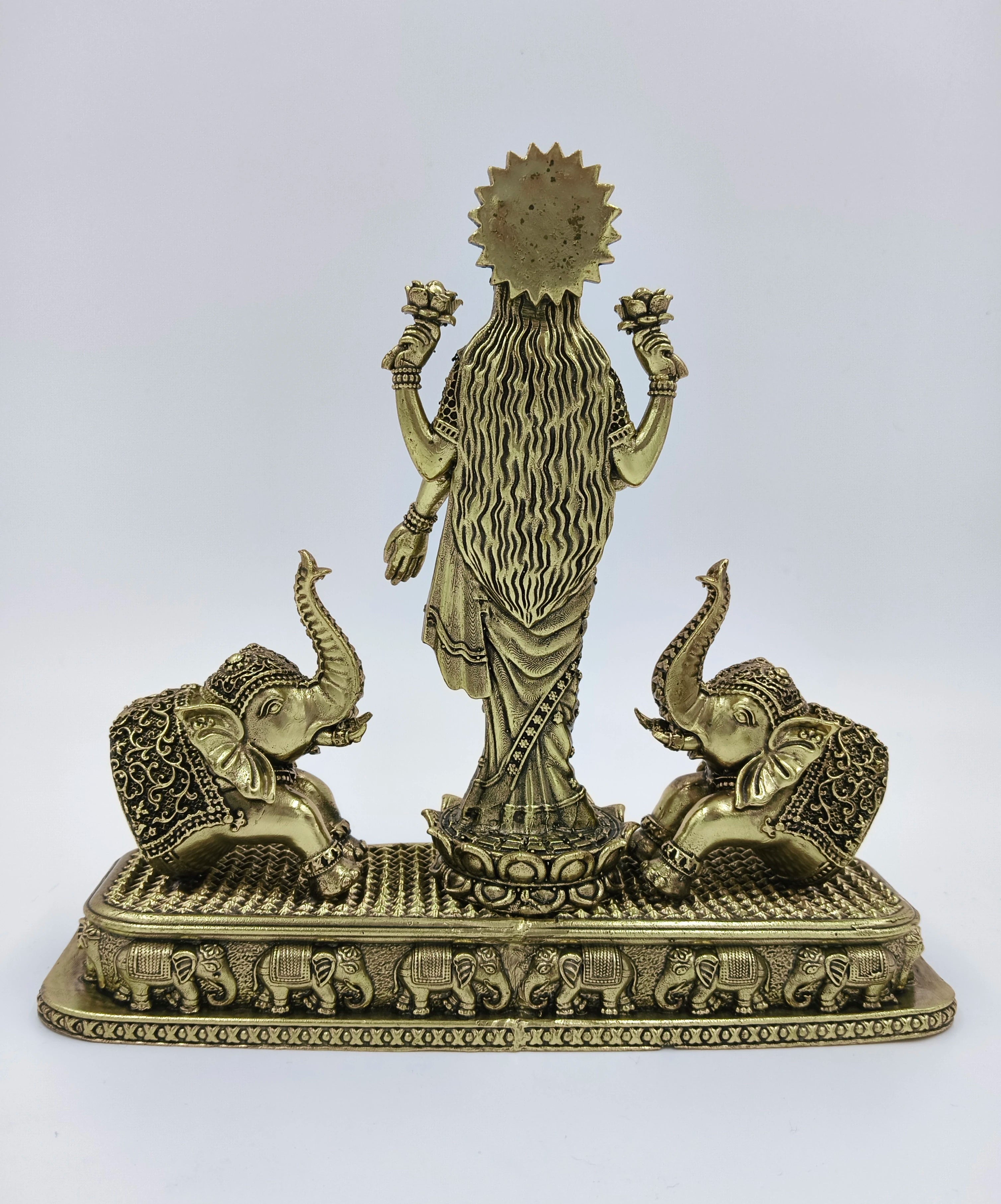 Back view of brass standing Gajalakshmi statue with two elephants on a decorated base