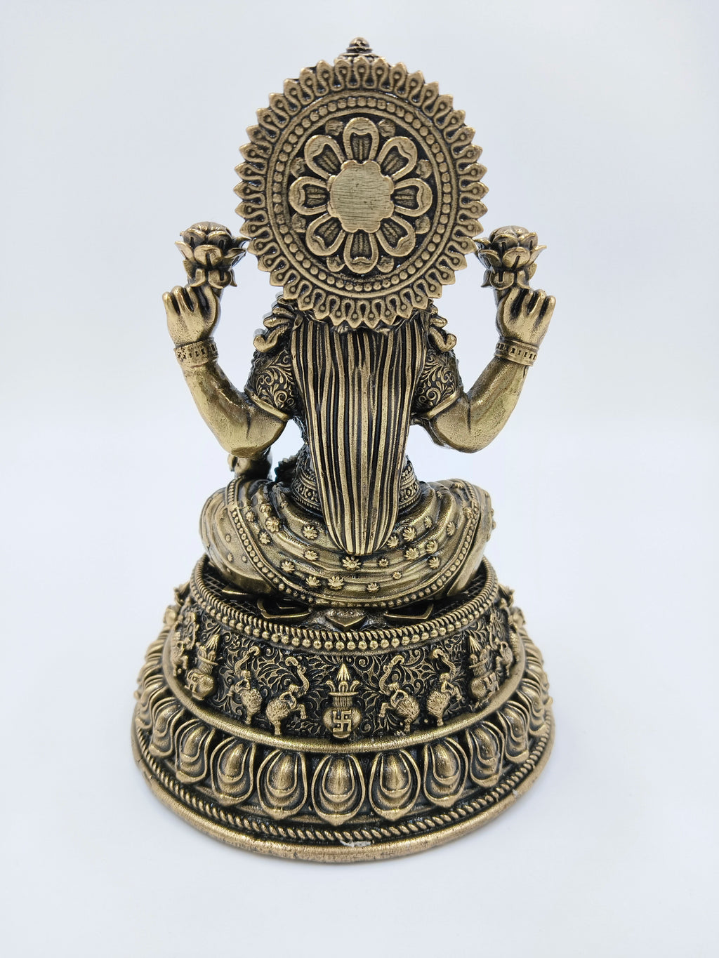 Back view of medium brass Lakshmi statue with floral and ornate designs