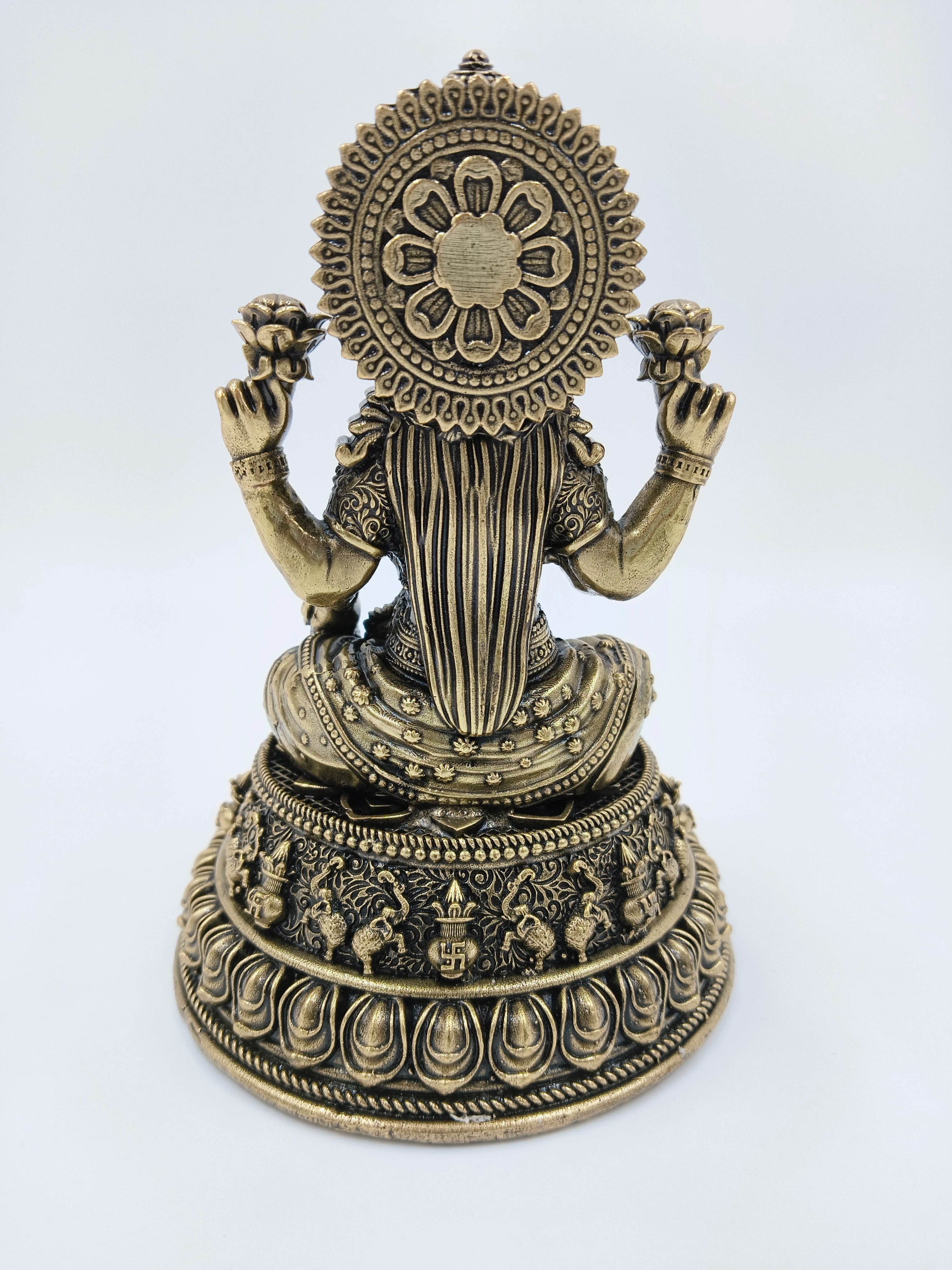 Back view of medium brass Lakshmi statue with floral and ornate designs