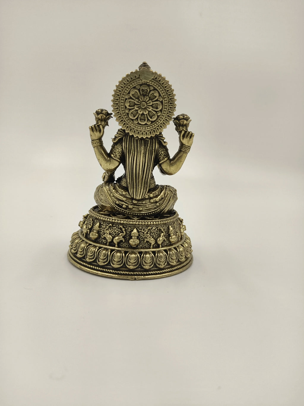 Back view of a small brass Padmini statue depicting deity Lakshmi holding lotus flowers