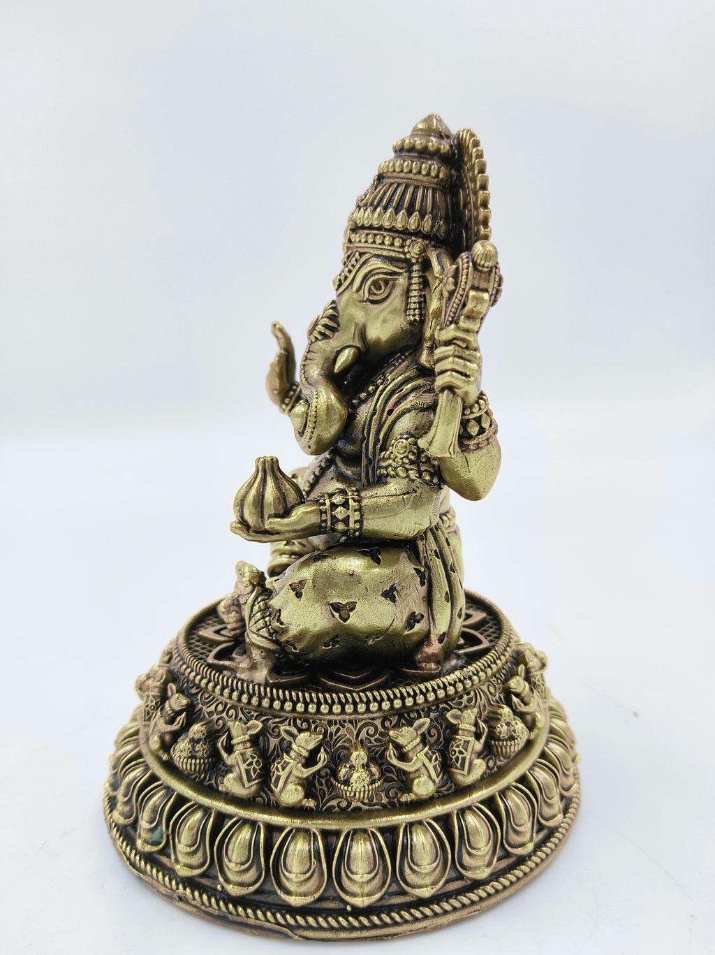Side view of medium brass Siddhi Ganapati idol seated on decorative base