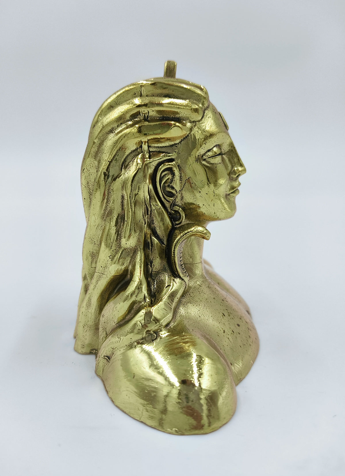 Side view of small brass Adiyogi Shiva sculpture with detailed hair and face