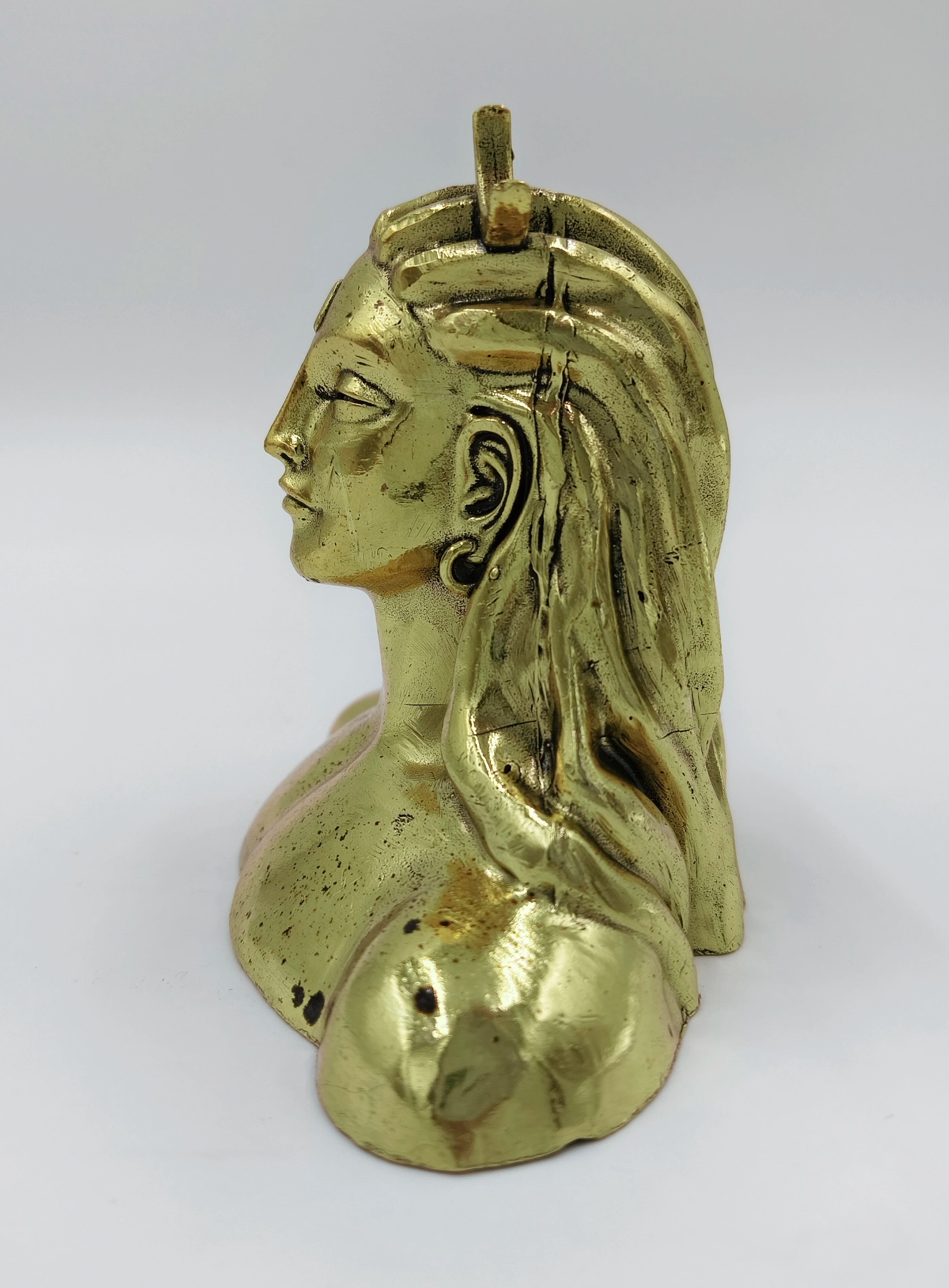 Side view of small brass Adiyogi Shiva sculpture with detailed hair and facial features