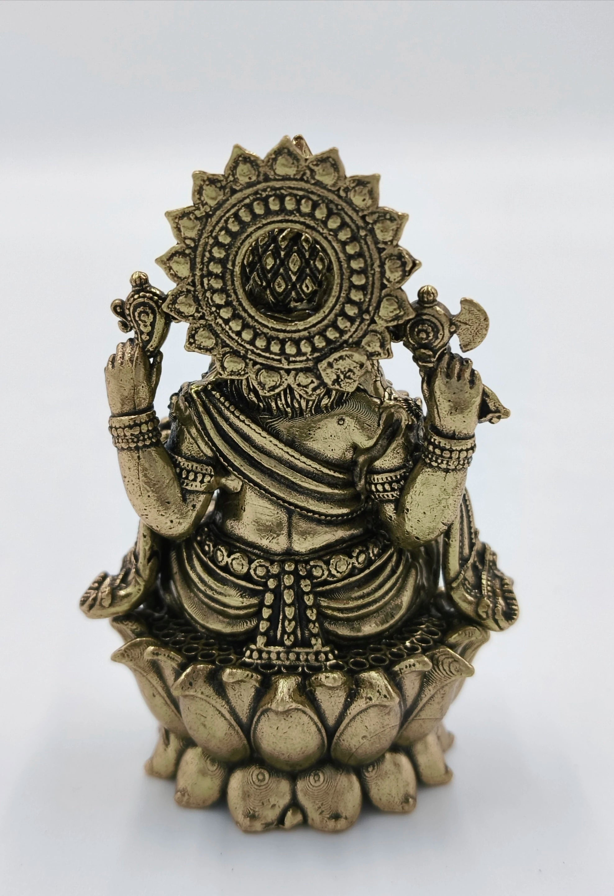 Rear view of compact brass Ganesh statue seated on lotus base