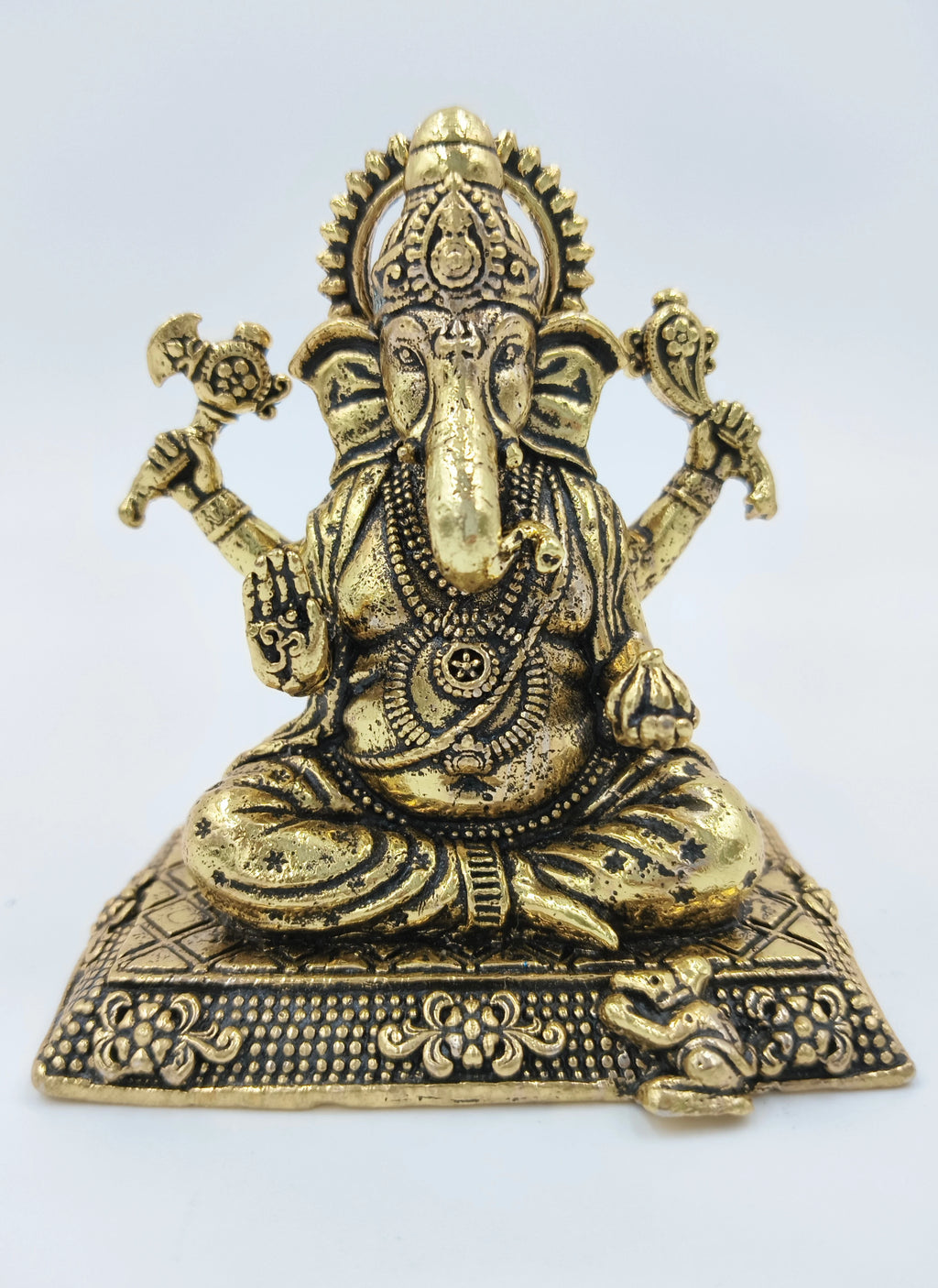 Small brass Ekadanta Ganesh idol seated on decorated base